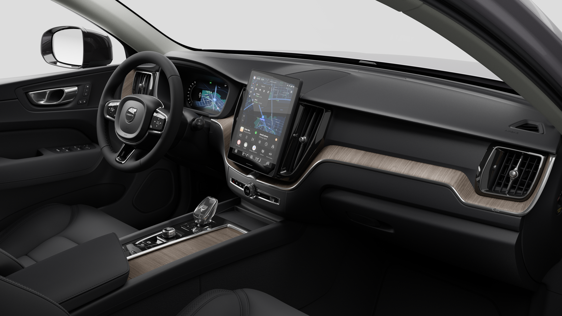 Interior view of a Volvo car showing the dashboard, steering wheel, center console, and digital display screen in a plain studio background.