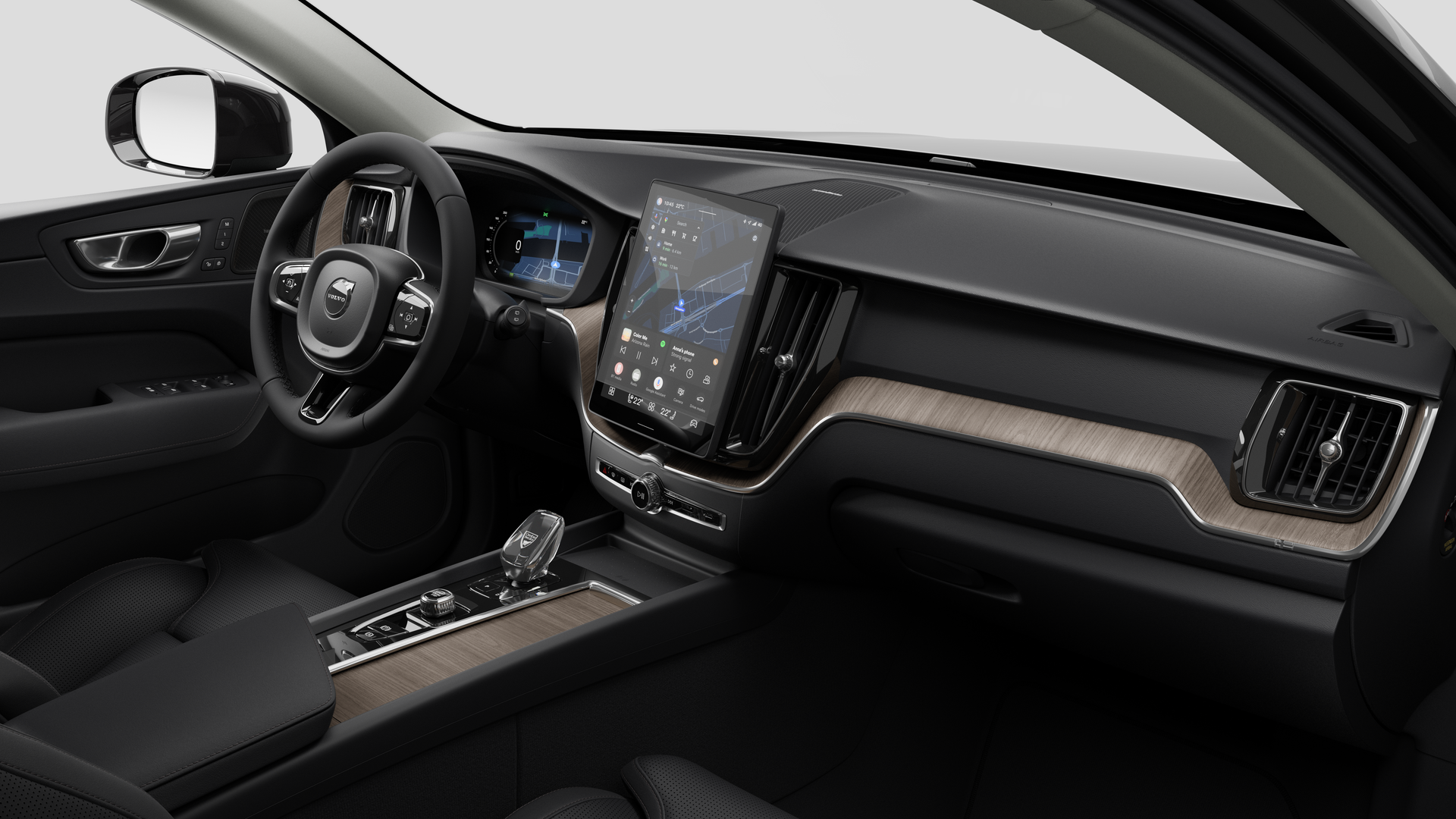 Vue intérieure d’une Volvo montrant le tableau de bord, le volant, la console centrale et l’écran d’affichage numérique sur un fond de studio uni.