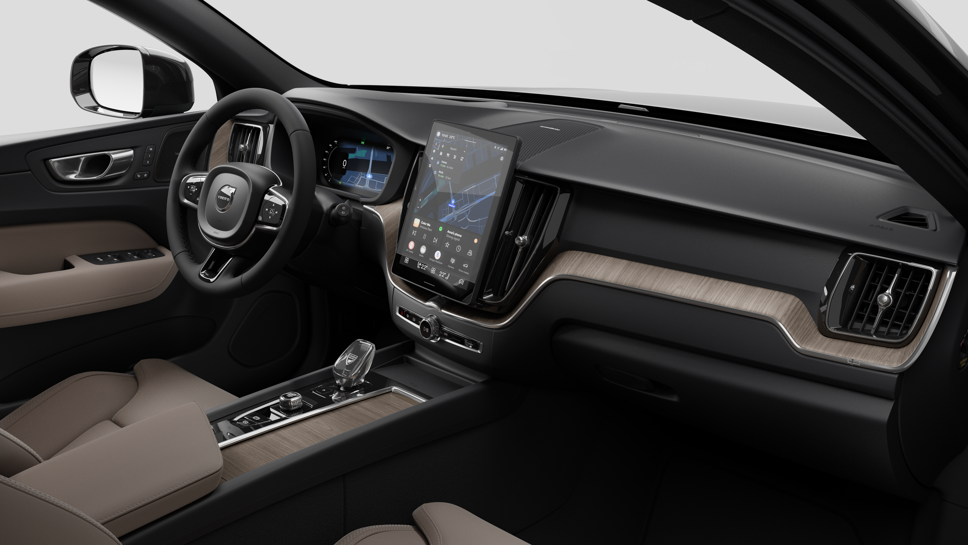 Vue intérieure d’une Volvo montrant le tableau de bord, le volant, la console centrale et l’écran d’affichage numérique sur un fond de studio uni.
