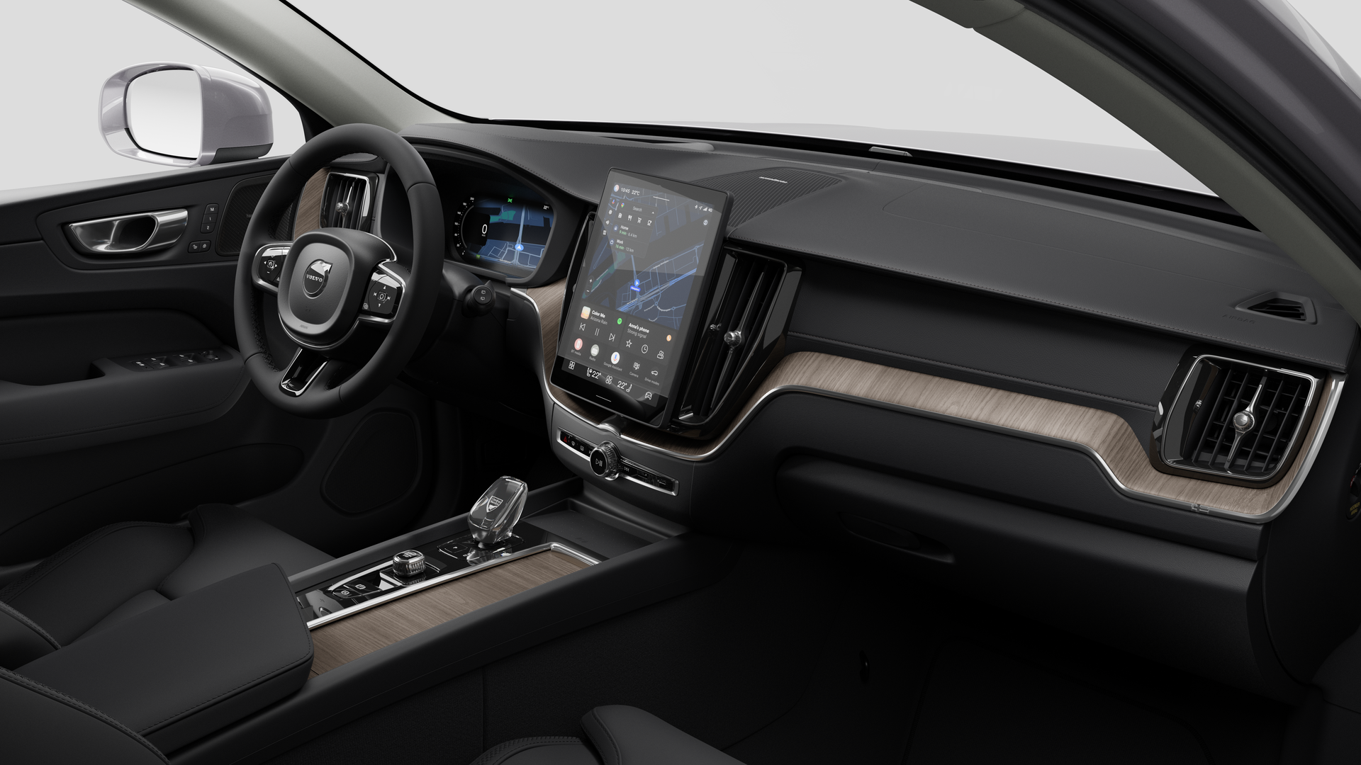 Vue intérieure d’une Volvo montrant le tableau de bord, le volant, la console centrale et l’écran d’affichage numérique sur un fond de studio uni.