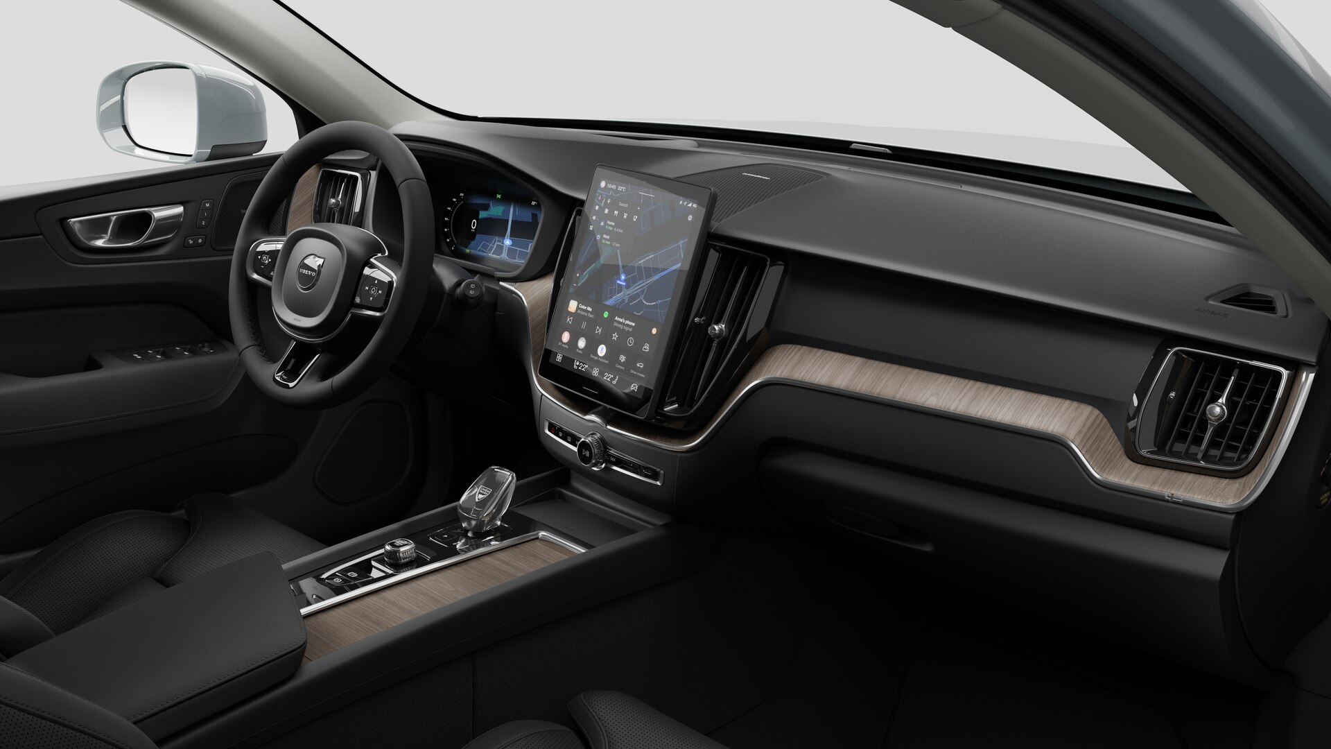 Vue intérieure d’une Volvo montrant le tableau de bord, le volant, la console centrale et l’écran d’affichage numérique sur un fond de studio uni.