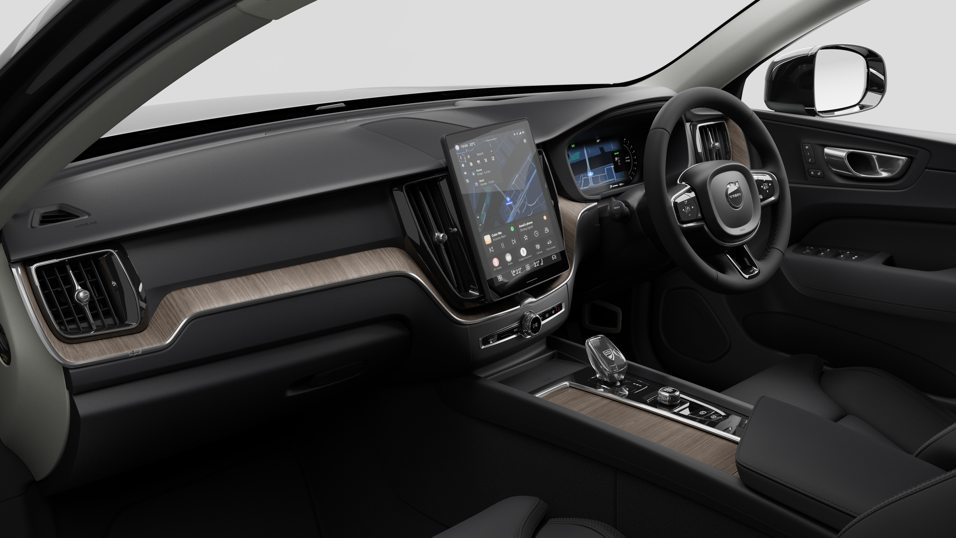 Interior view of a Volvo car showing the dashboard, steering wheel, center console, and digital display screen in a plain studio background.
