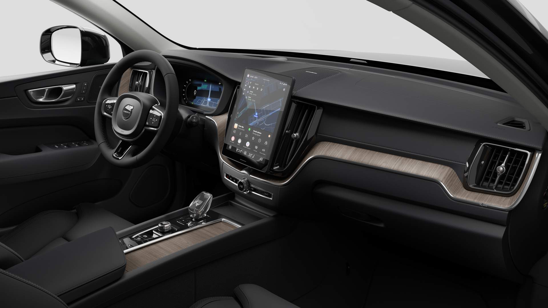 Vue intérieure d’une Volvo montrant le tableau de bord, le volant, la console centrale et l’écran d’affichage numérique sur un fond de studio uni.