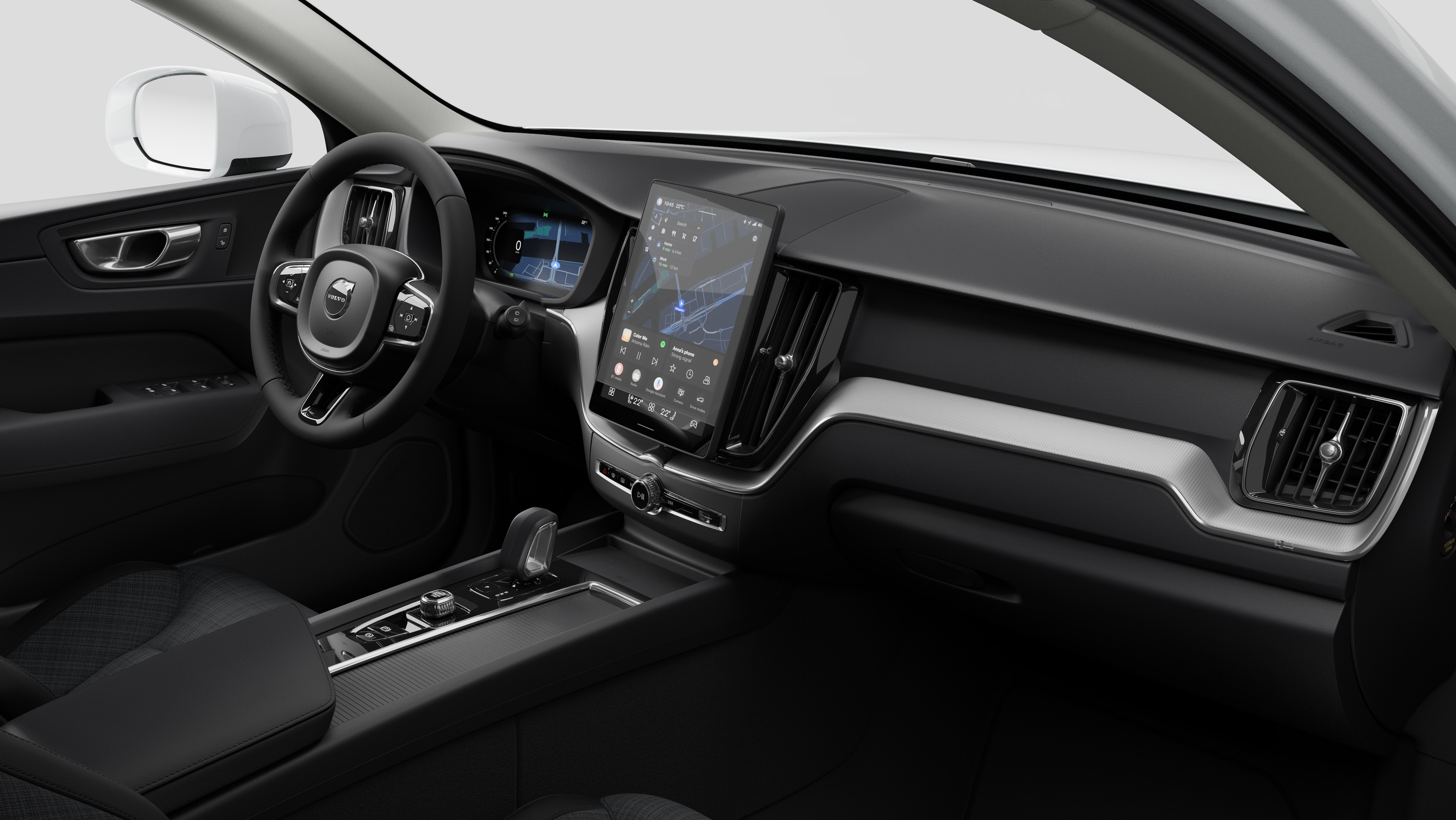 Vista interna di un'auto Volvo che mostra il cruscotto, il volante, la console centrale e lo schermo digitale sullo sfondo di uno studio.