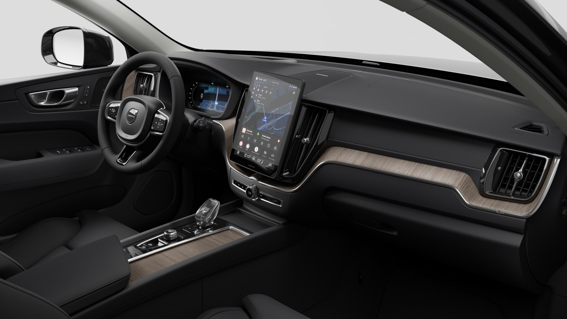 Vue intérieure d’une Volvo montrant le tableau de bord, le volant, la console centrale et l’écran d’affichage numérique sur un fond de studio uni.