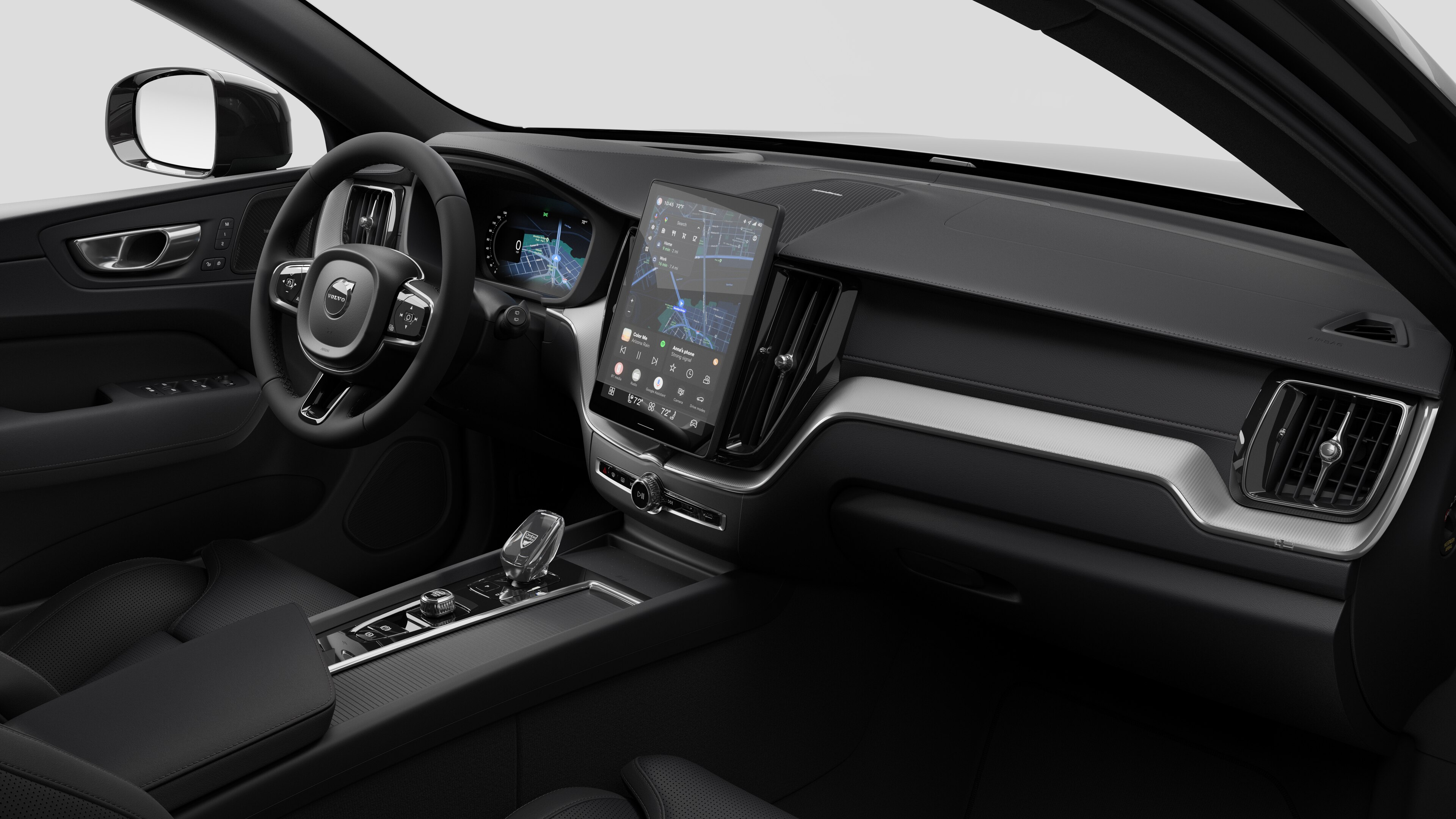 Interior view of a Volvo car showing the dashboard, steering wheel, center console, and digital display screen in a plain studio background.