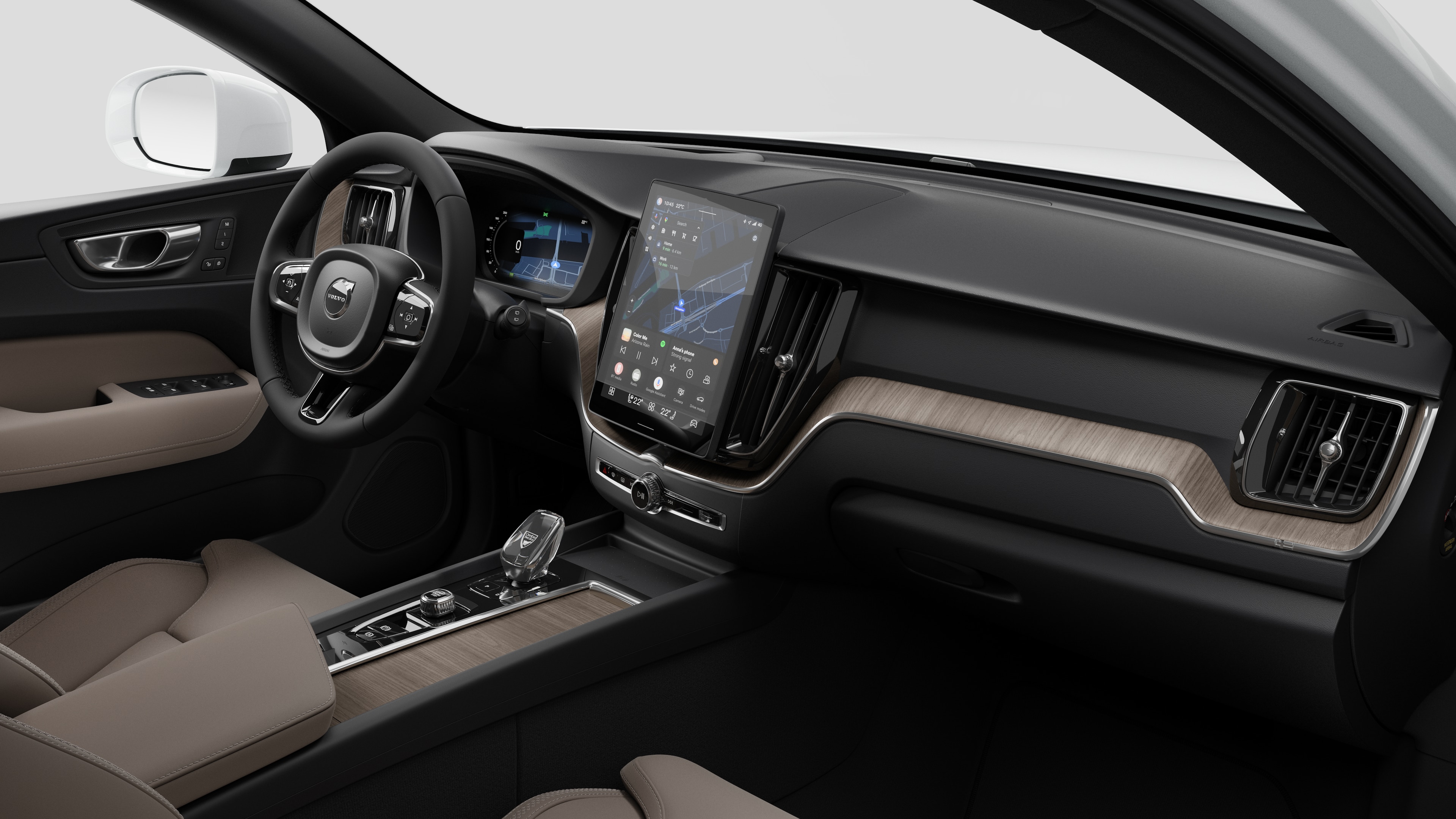 대시보드, 스티어링 휠, 센터 콘솔 및 디지털 디스플레이 화면을 평범한 스튜디오 배경에 보여주는 Volvo 자동차의 내부 모습.