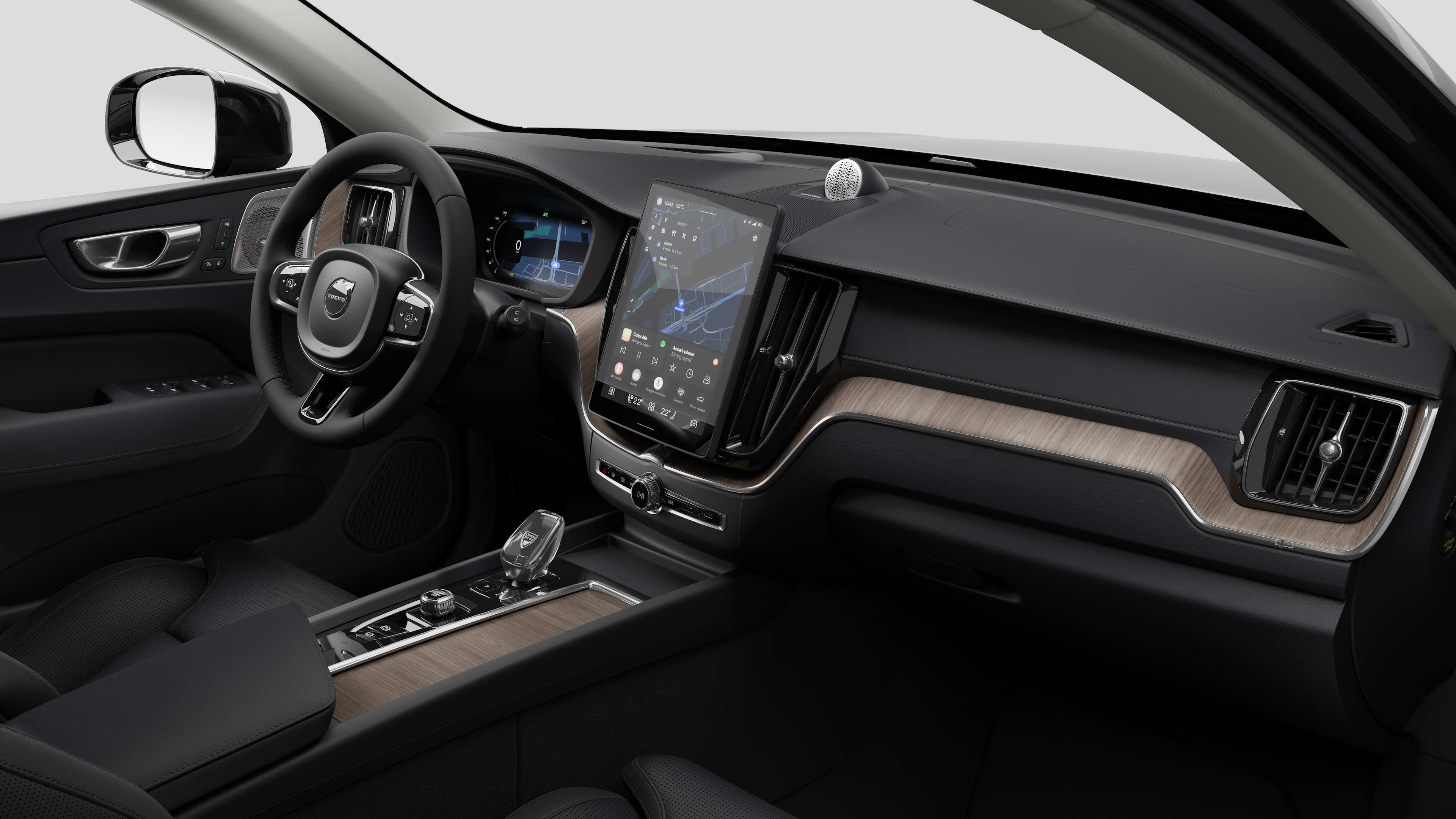 Interior view of a Volvo car showing the dashboard, steering wheel, center console, and digital display screen in a plain studio background.