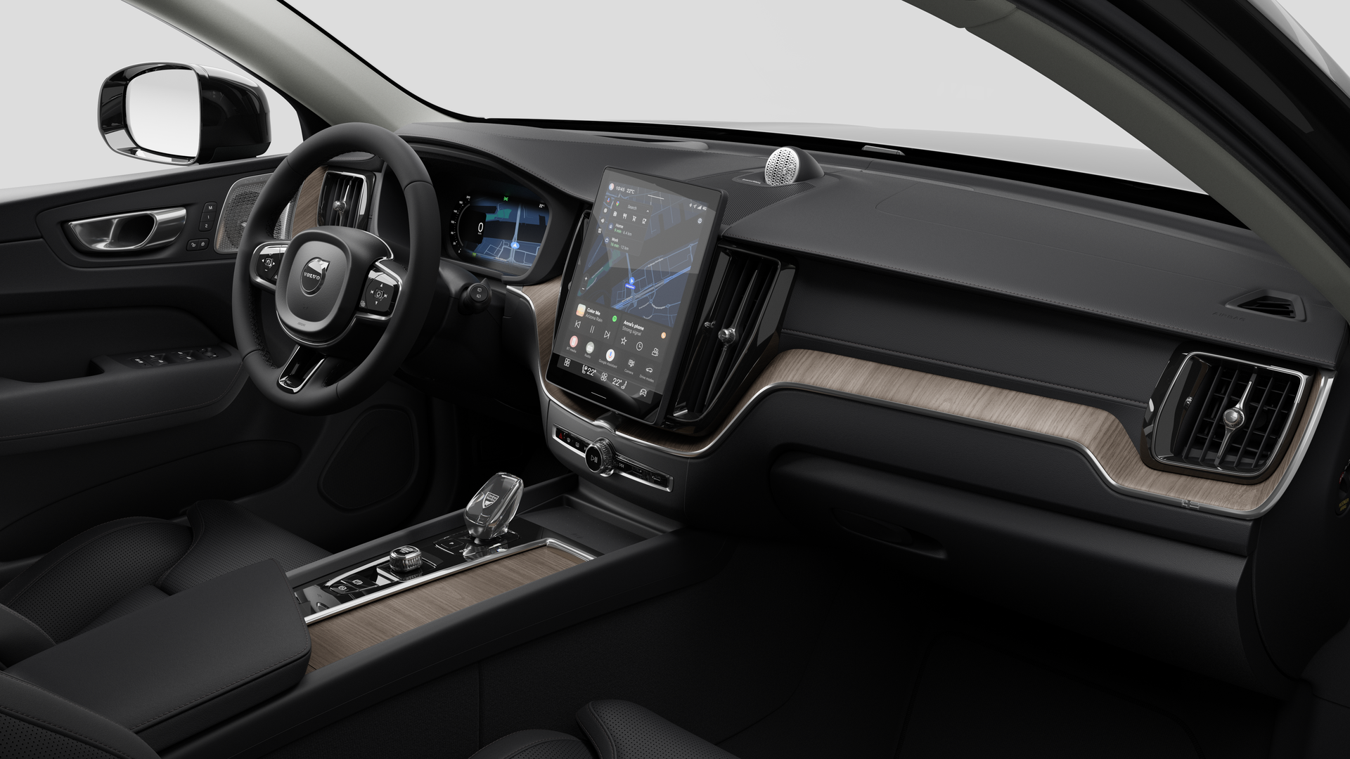 Interior view of a Volvo car showing the dashboard, steering wheel, center console, and digital display screen in a plain studio background.