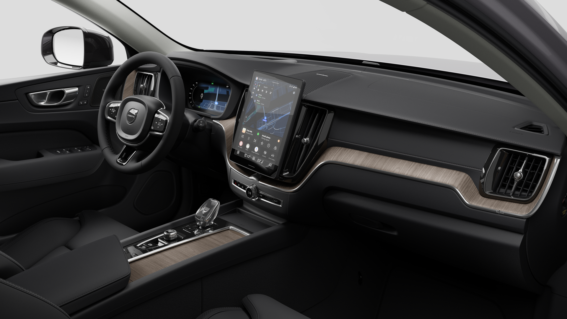 Vue intérieure d’une Volvo montrant le tableau de bord, le volant, la console centrale et l’écran d’affichage numérique sur un fond de studio uni.