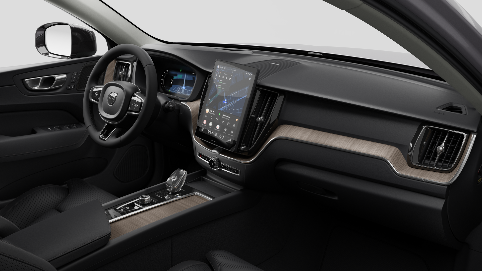Vue intérieure d’une Volvo montrant le tableau de bord, le volant, la console centrale et l’écran d’affichage numérique sur un fond de studio uni.