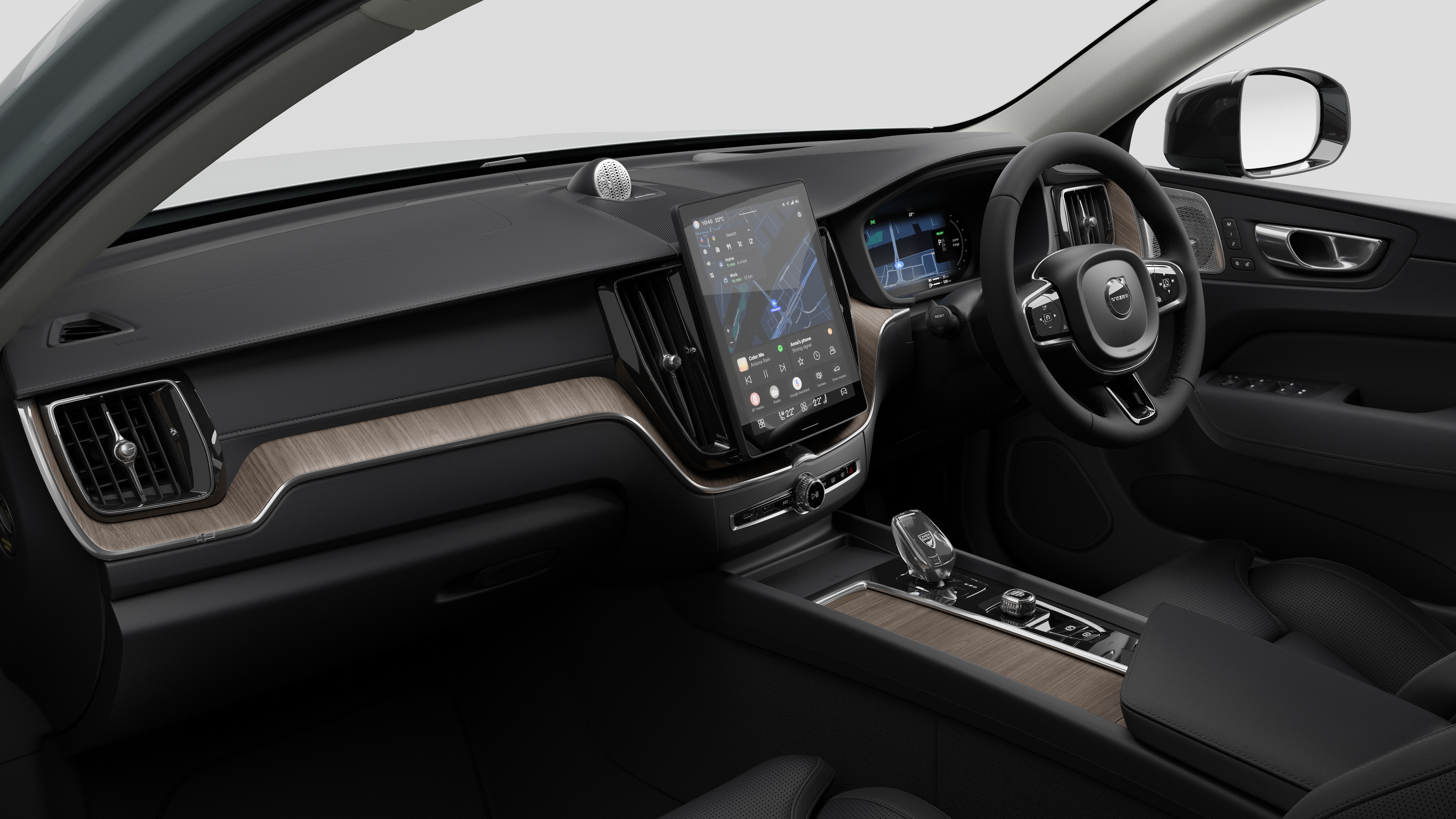 Interior view of a Volvo car showing the dashboard, steering wheel, center console, and digital display screen in a plain studio background.