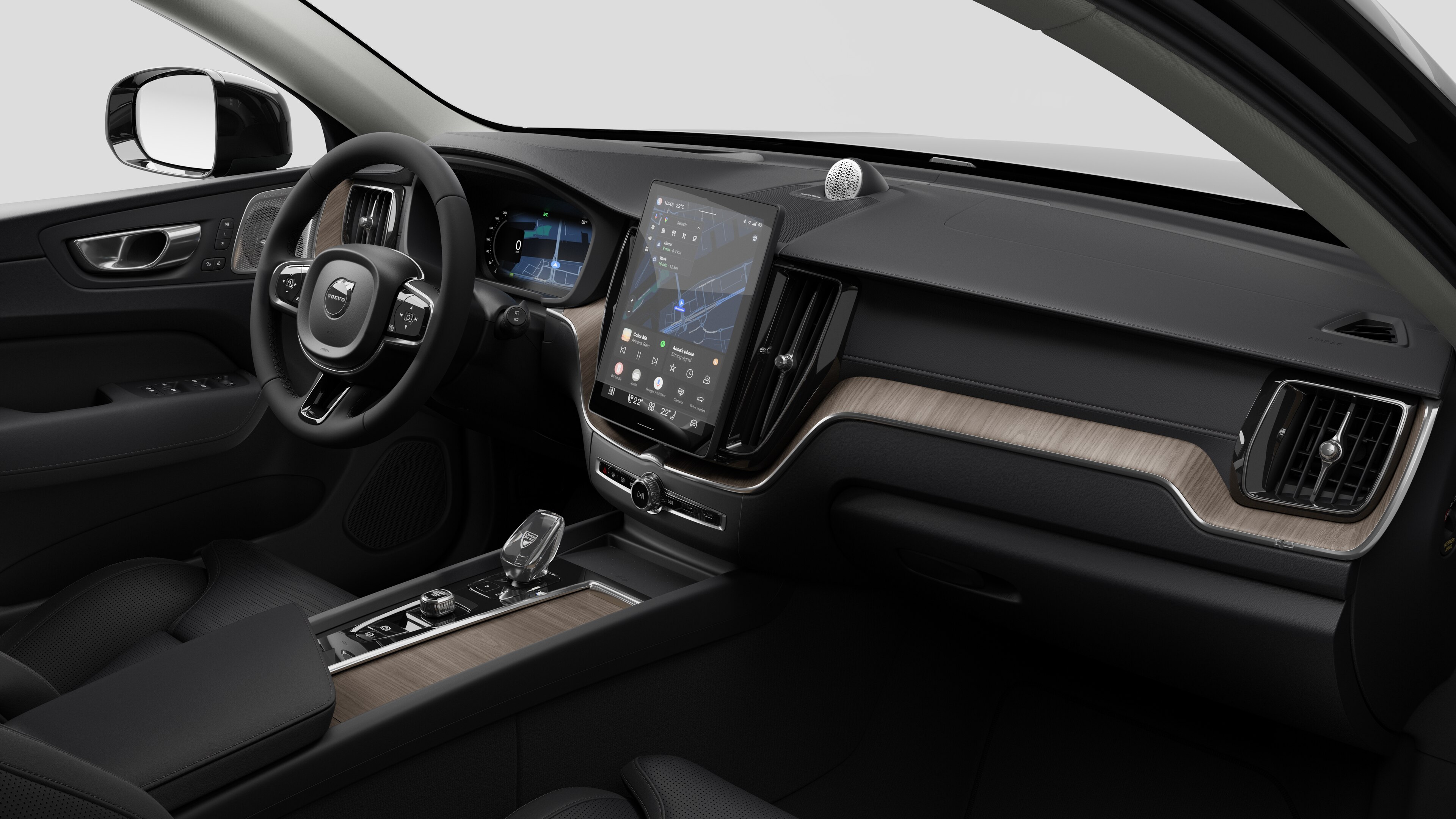 Interior view of a Volvo car showing the dashboard, steering wheel, center console, and digital display screen in a plain studio background.