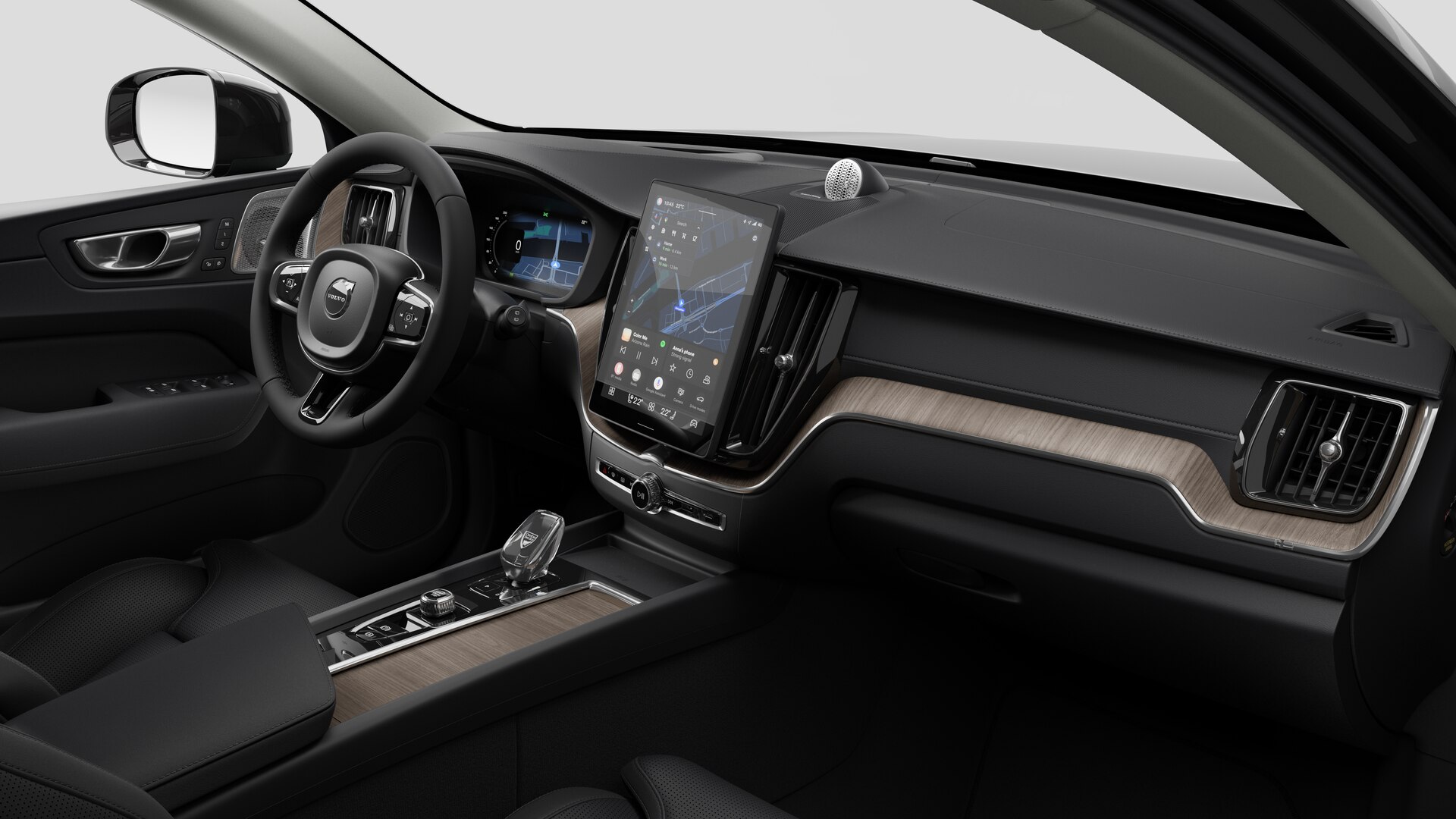 Vue intérieure d’une Volvo montrant le tableau de bord, le volant, la console centrale et l’écran d’affichage numérique sur un fond de studio uni.
