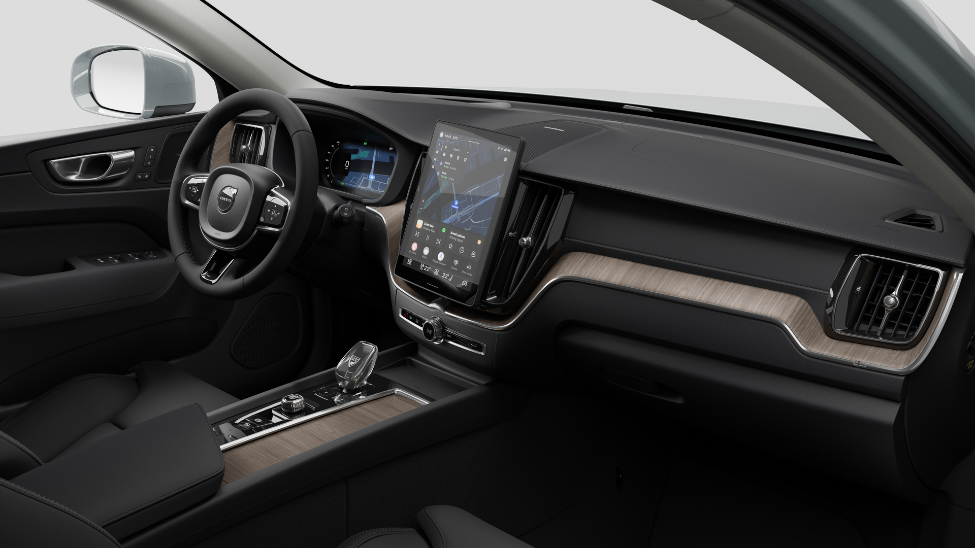 Vue intérieure d’une Volvo montrant le tableau de bord, le volant, la console centrale et l’écran d’affichage numérique sur un fond de studio uni.