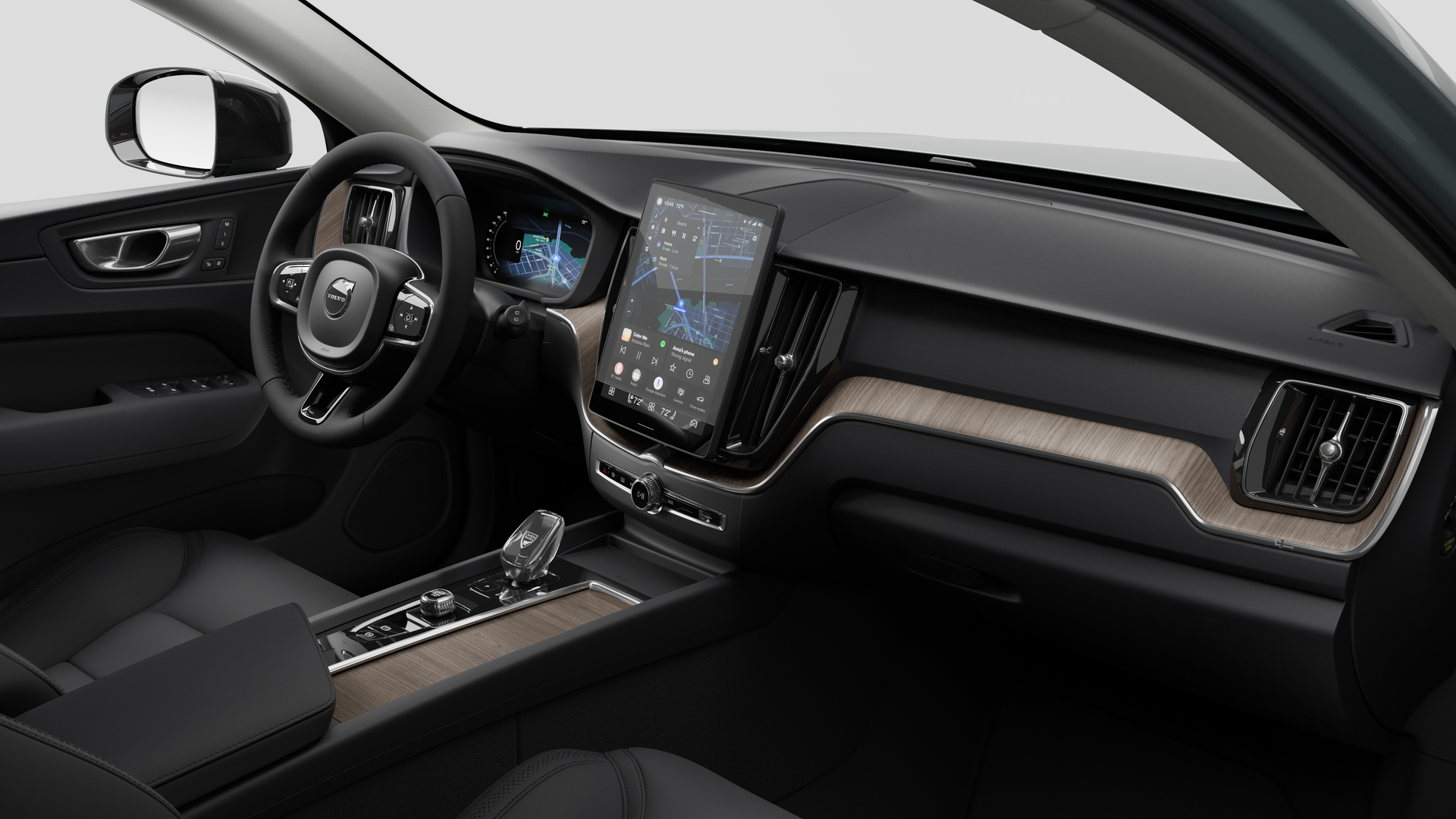 Interior view of a Volvo car showing the dashboard, steering wheel, center console, and digital display screen in a plain studio background.