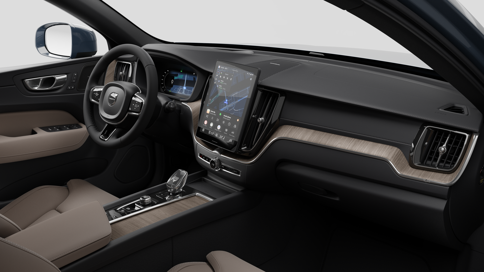 Vue intérieure d’une Volvo montrant le tableau de bord, le volant, la console centrale et l’écran d’affichage numérique sur un fond de studio uni.