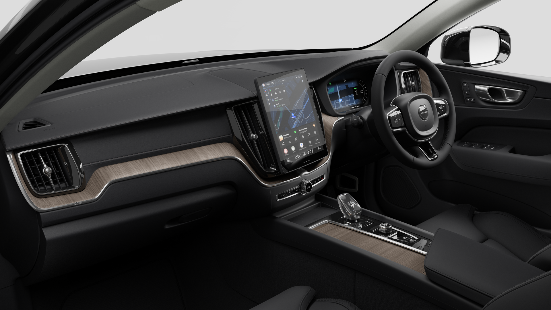 Interior view of a Volvo car showing the dashboard, steering wheel, center console, and digital display screen in a plain studio background.