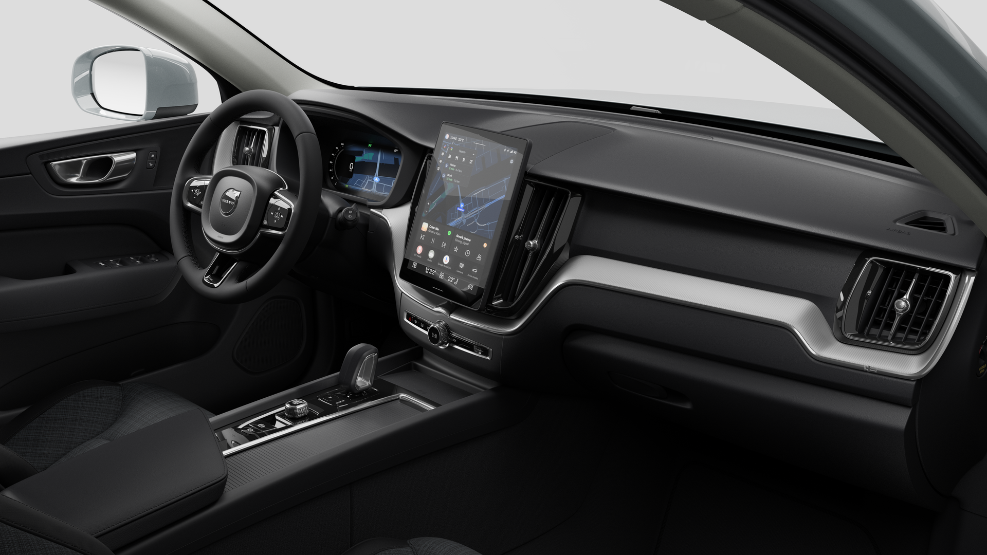 Vue intérieure d’une Volvo montrant le tableau de bord, le volant, la console centrale et l’écran d’affichage numérique sur un fond de studio uni.