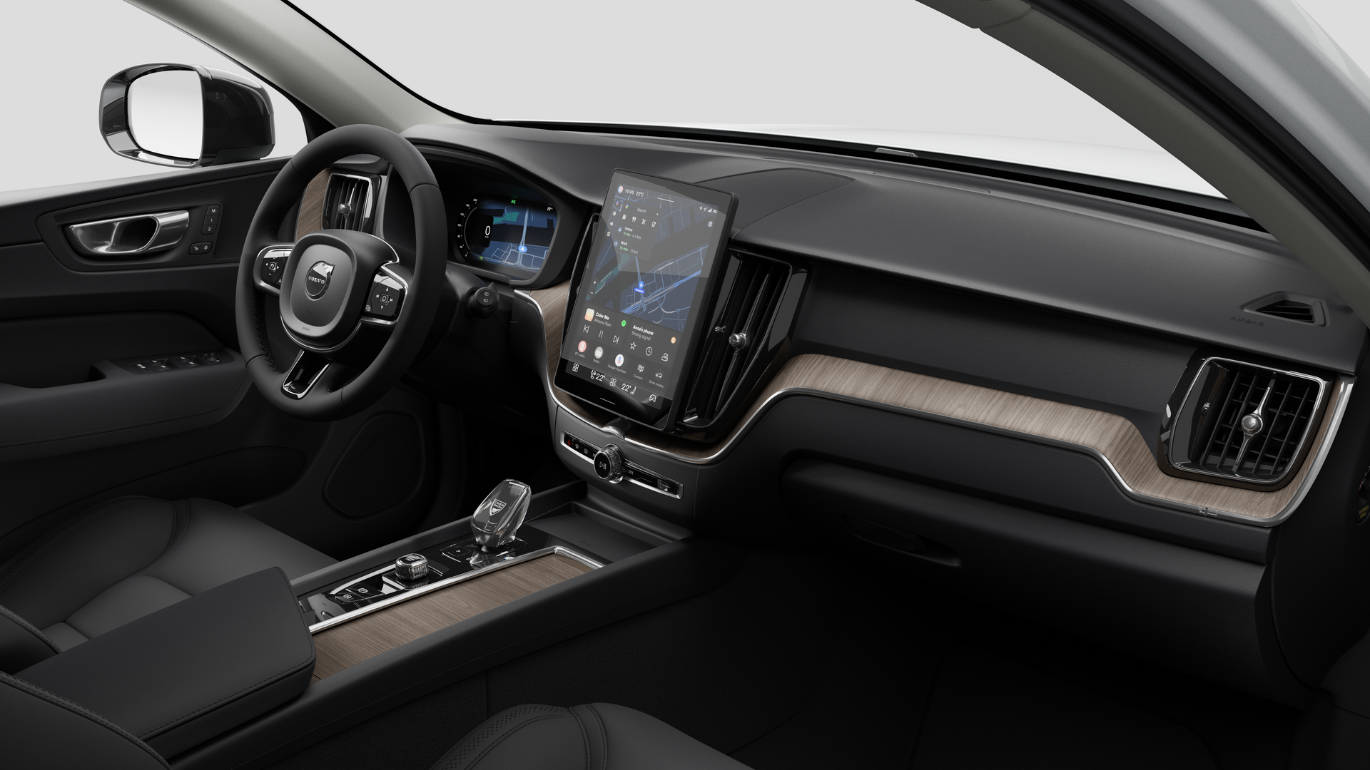 Interior view of a Volvo car showing the dashboard, steering wheel, center console, and digital display screen in a plain studio background.