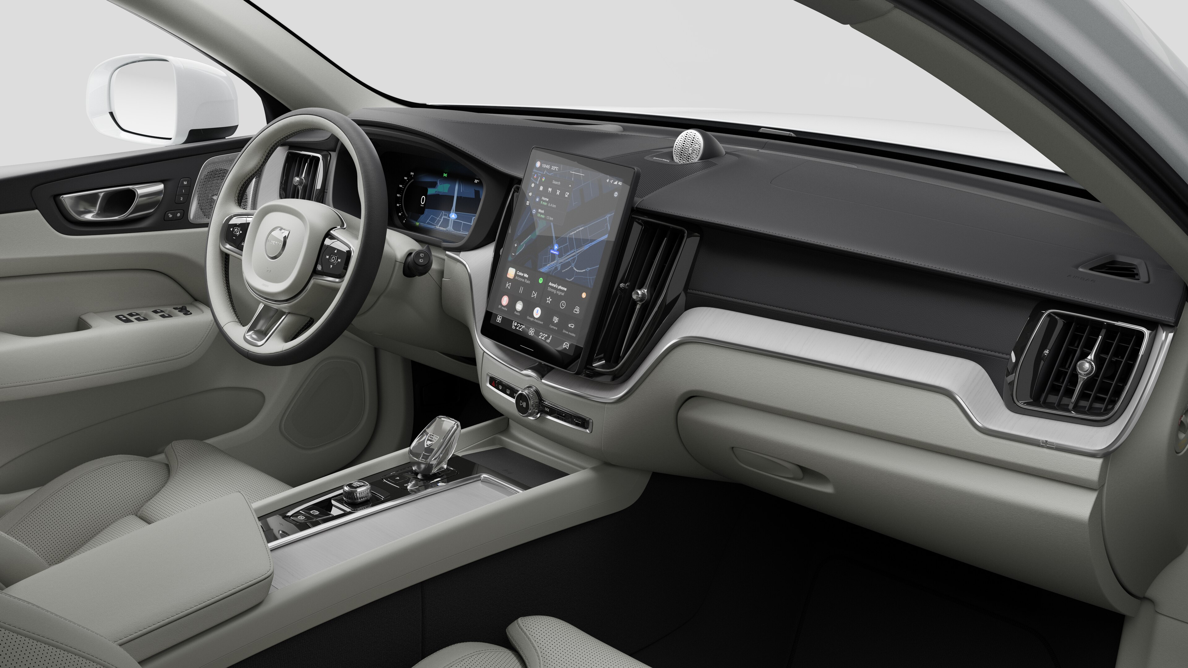 대시보드, 스티어링 휠, 센터 콘솔 및 디지털 디스플레이 화면을 평범한 스튜디오 배경에 보여주는 Volvo 자동차의 내부 모습.