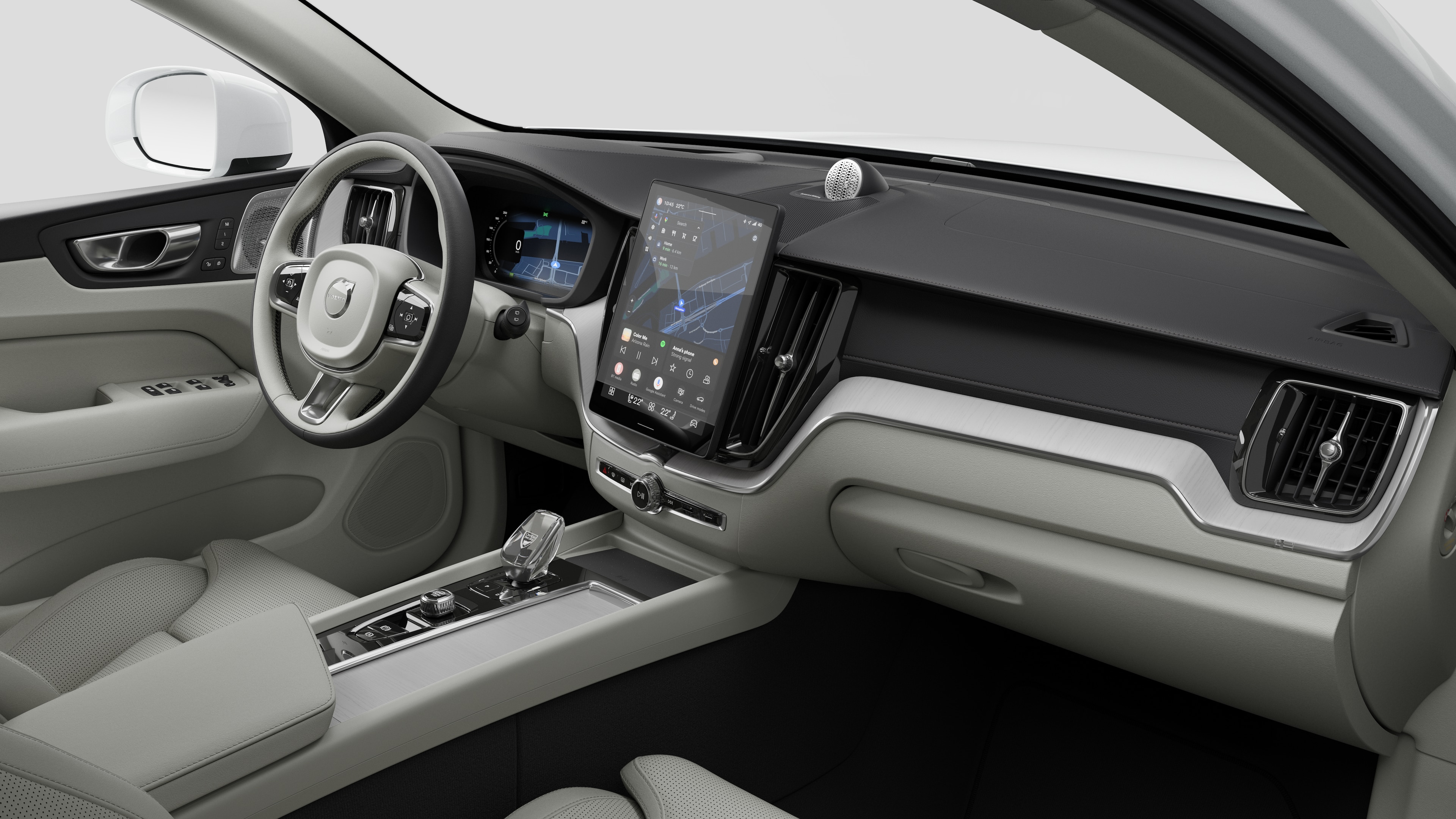 대시보드, 스티어링 휠, 센터 콘솔 및 디지털 디스플레이 화면을 평범한 스튜디오 배경에 보여주는 Volvo 자동차의 내부 모습.