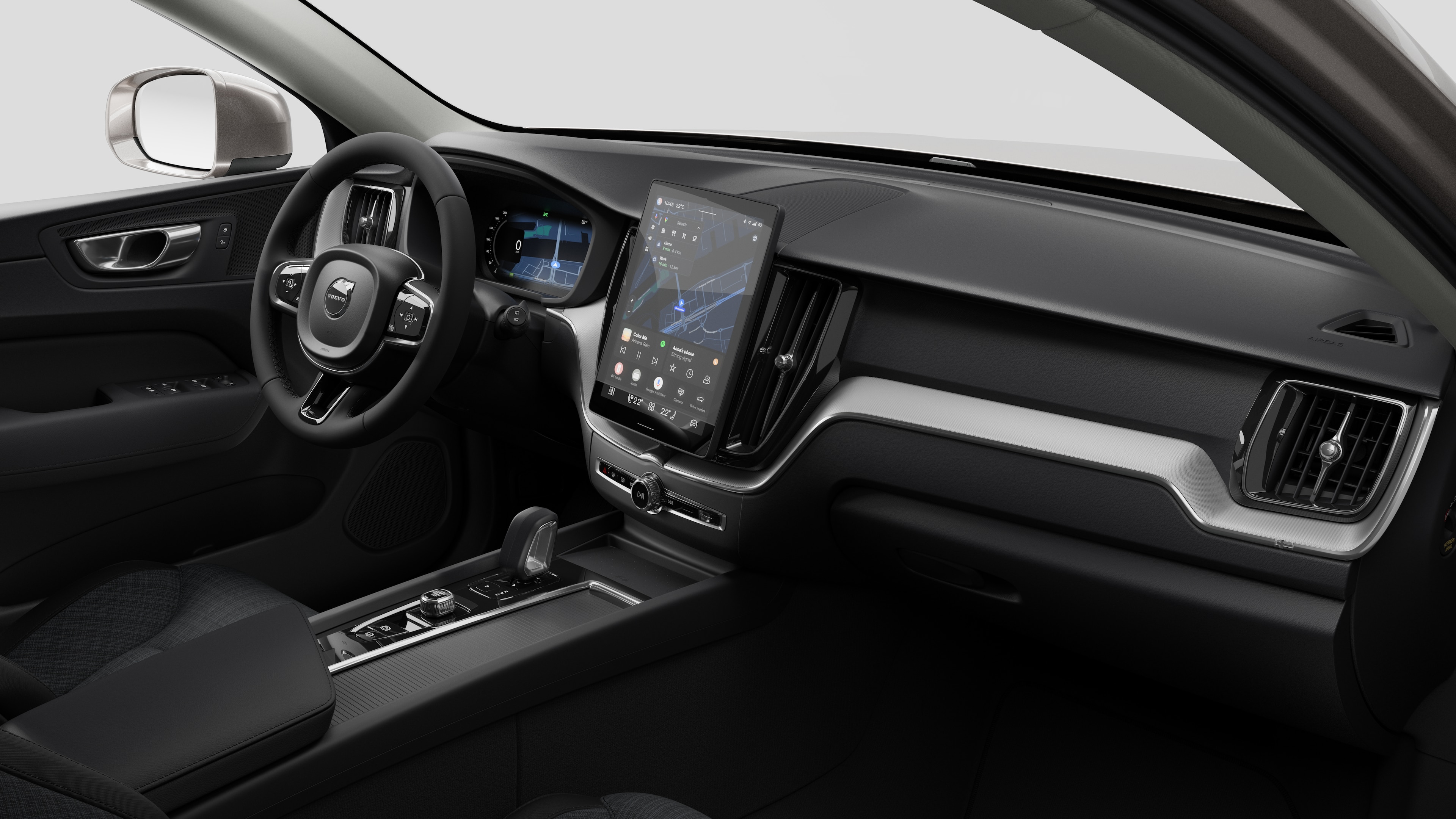 Vista interna di un'auto Volvo che mostra il cruscotto, il volante, la console centrale e lo schermo digitale sullo sfondo di uno studio.