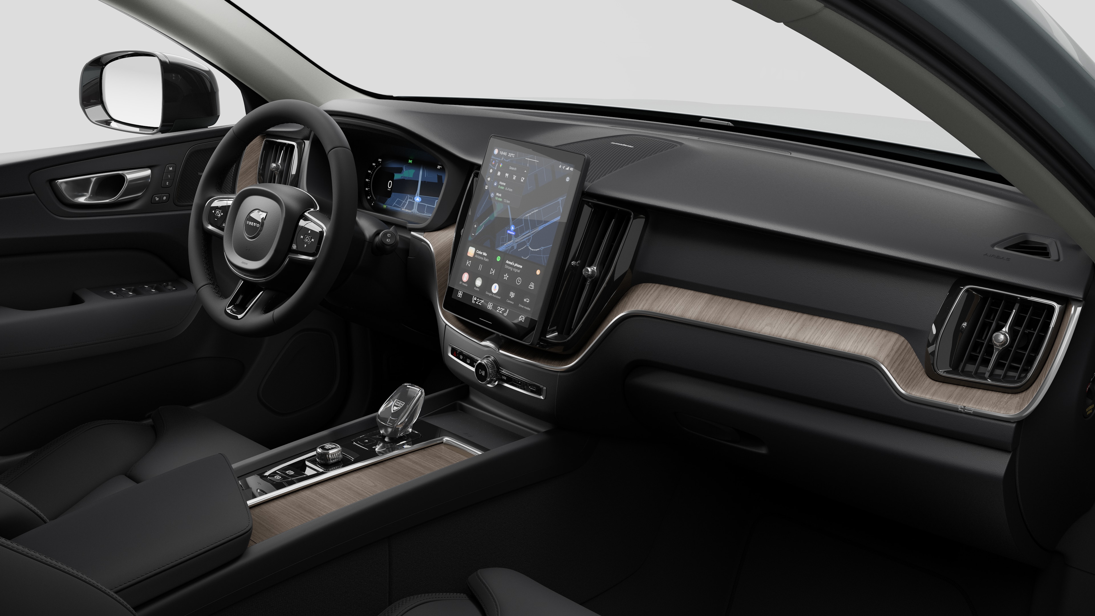 Volvo automašīnas salona skats, kurā redzams mērinstrumentu panelis, stūre, viduskonsole un digitālais displeja ekrāns vienkāršā studijas fonā.