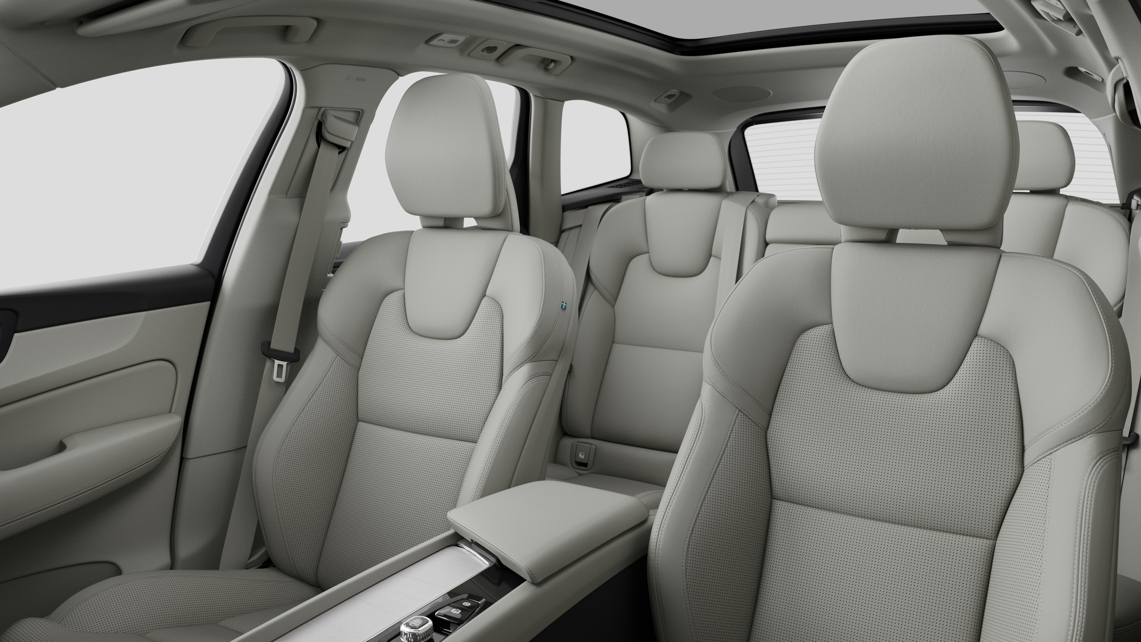 평범한 스튜디오 배경에 뒷좌석 조수석과 중앙 콘솔을 보여주는 볼보 자동차 내부.