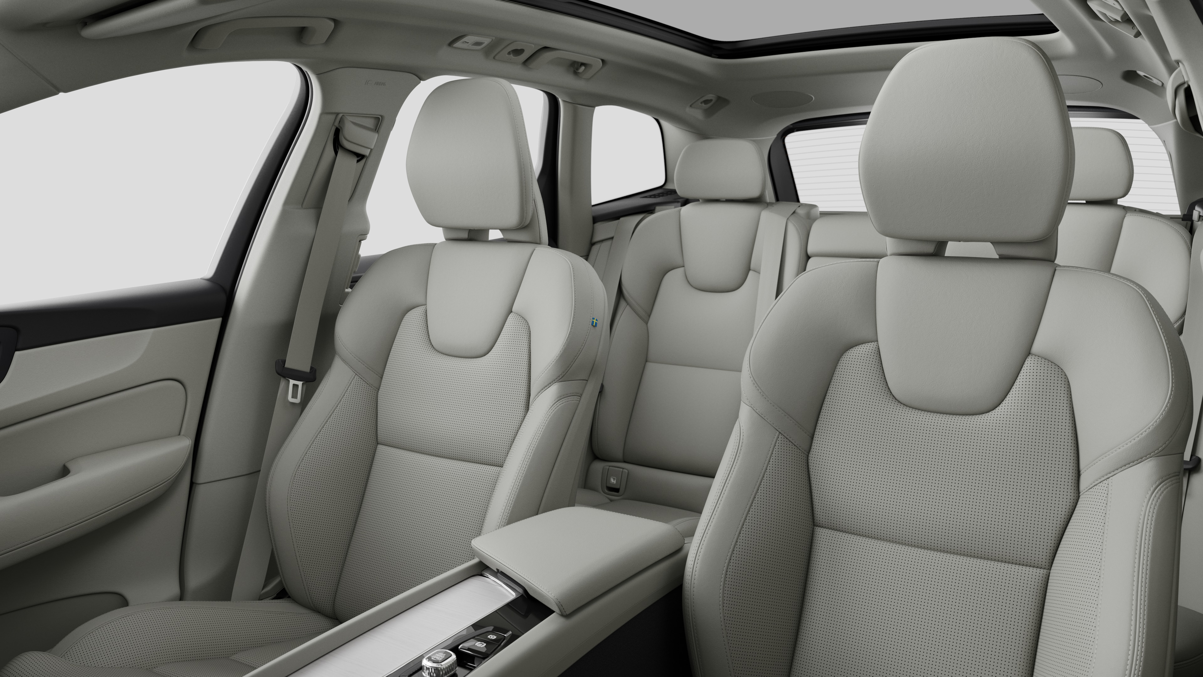 평범한 스튜디오 배경에 뒷좌석 조수석과 중앙 콘솔을 보여주는 볼보 자동차 내부.