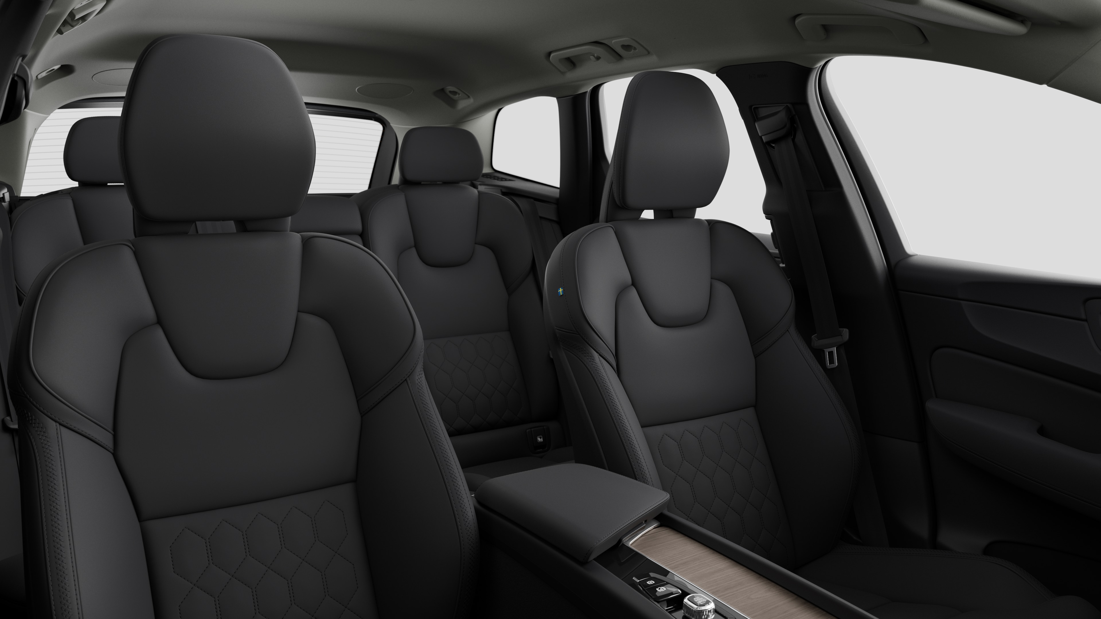Volvo car interior showing rear passenger seats and center console in plain studio background.