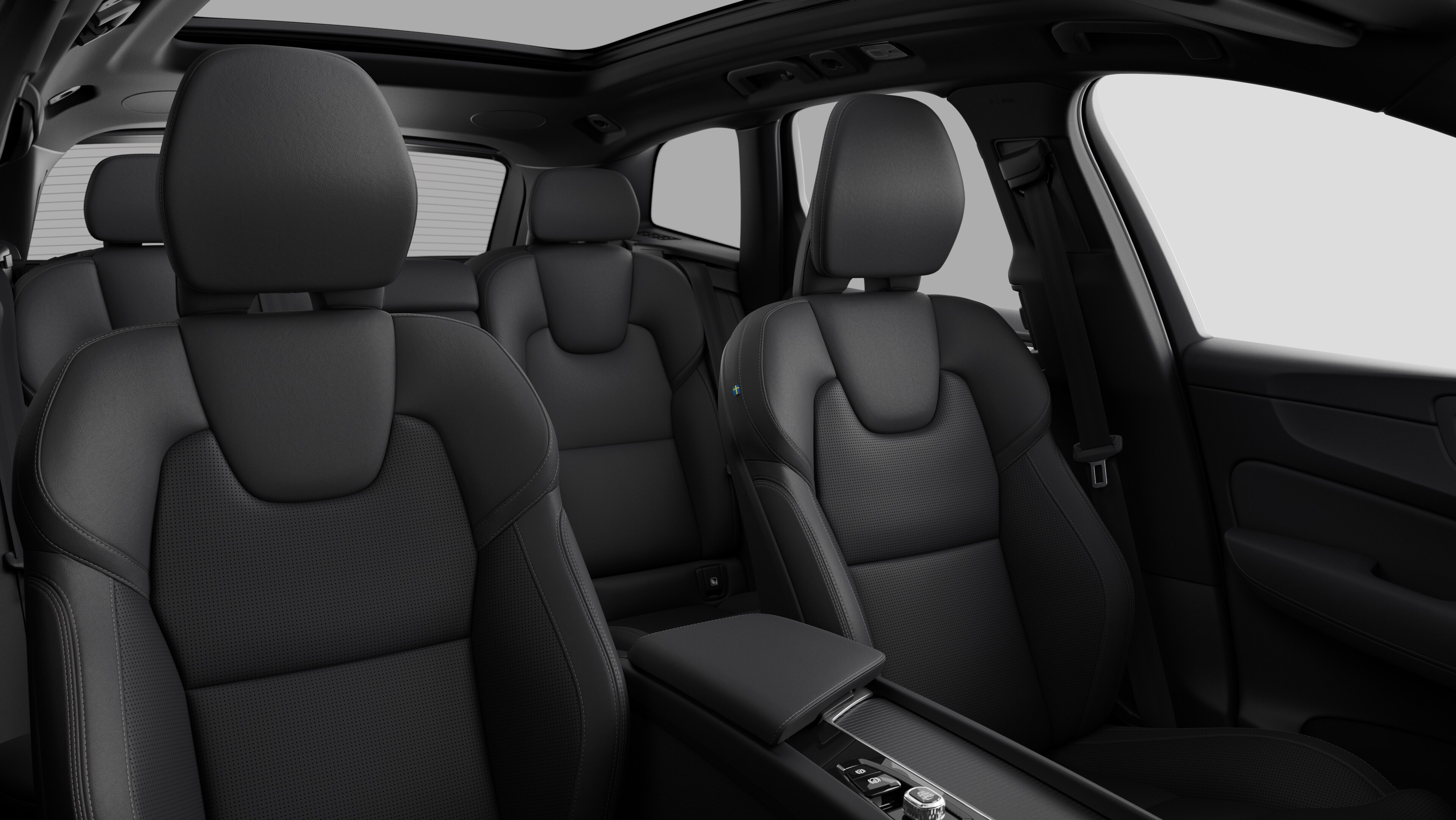 無地のスタジオを背景に、後部座席とセンターコンソールを収めたボルボ車のインテリア。