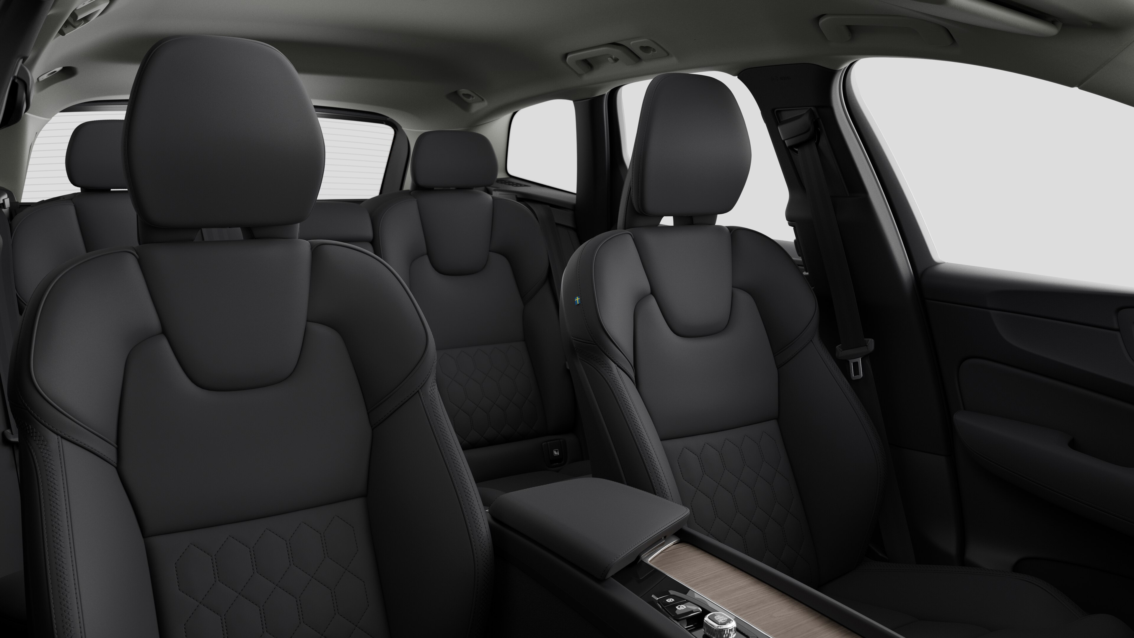 Volvo car interior showing rear passenger seats and center console in plain studio background.