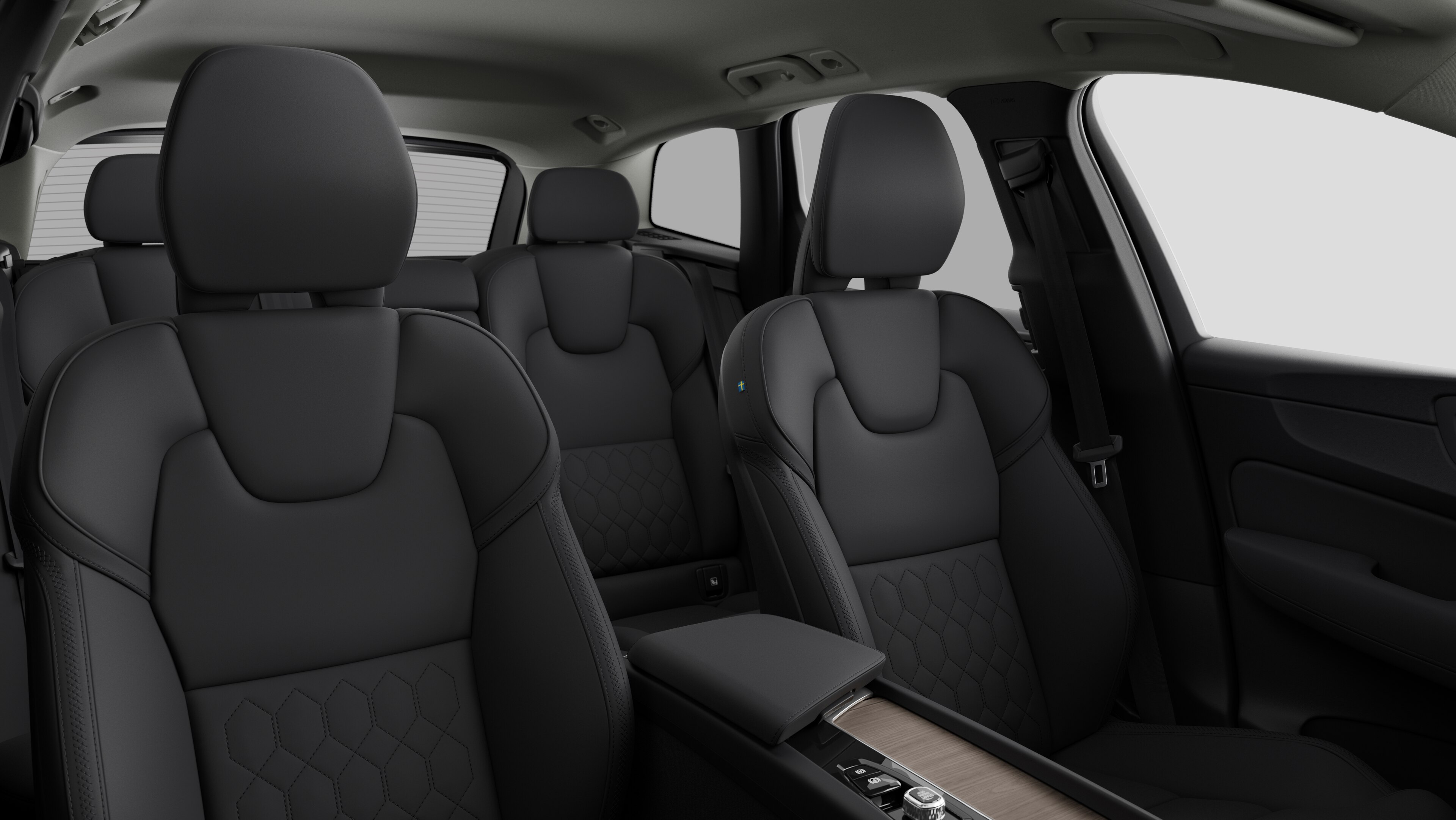 無地のスタジオを背景に、後部座席とセンターコンソールを収めたボルボ車のインテリア。