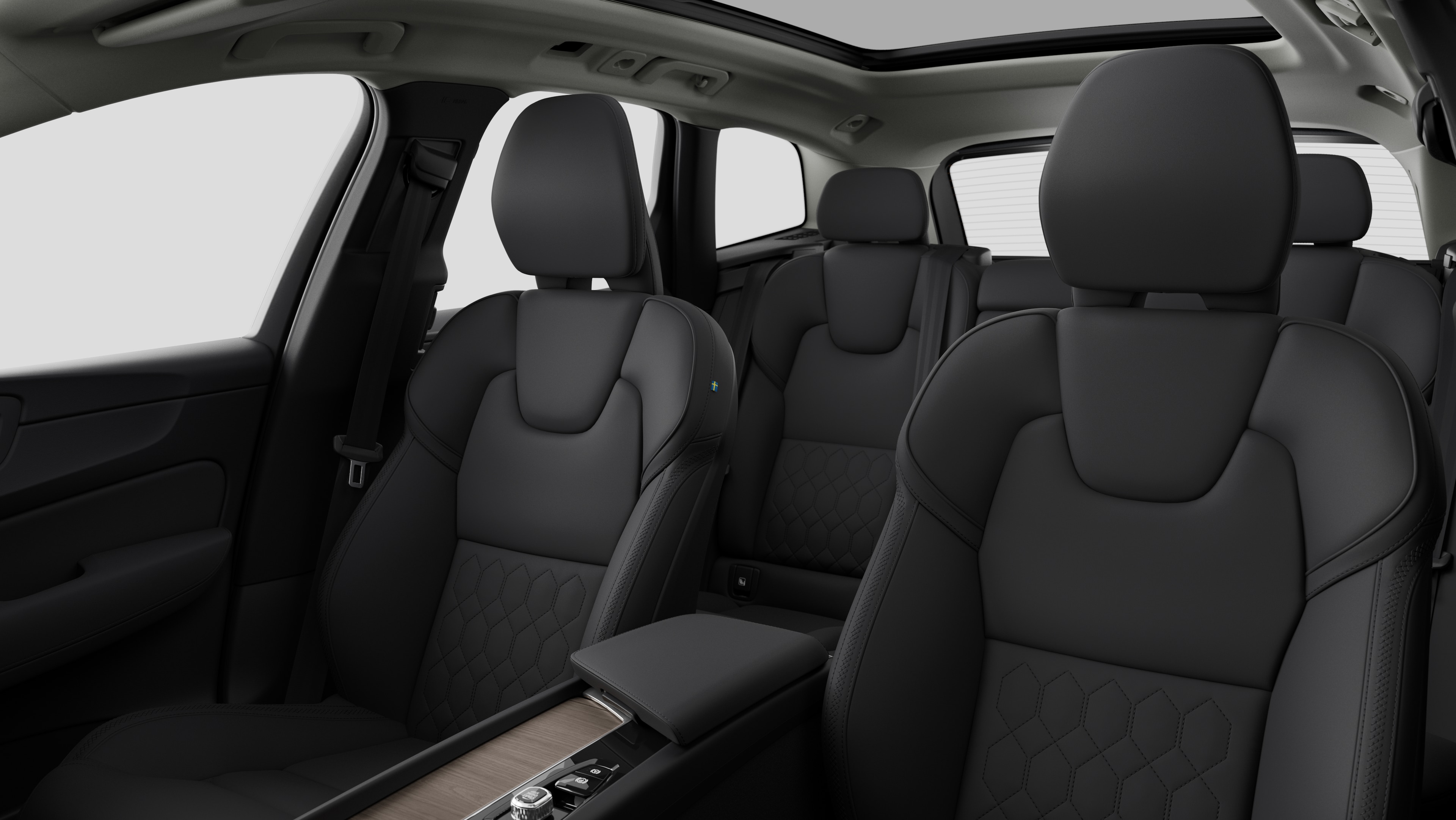 Interior del vehículo Volvo que muestra los asientos traseros del pasajero y la consola central en un fondo de estudio liso.