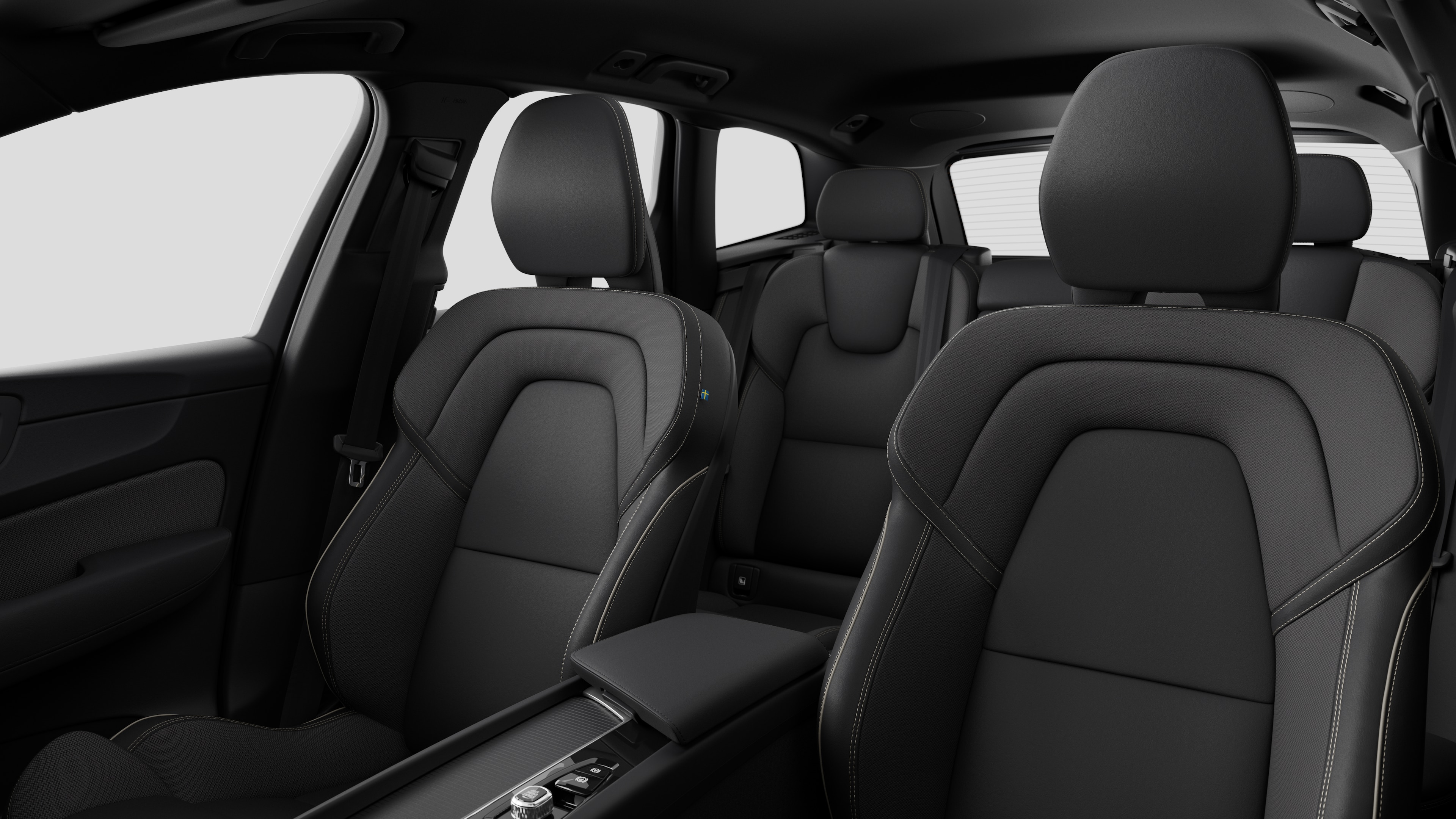 Interiér vozu Volvo se zadními sedadly spolujezdce a středovou konzolou v jednoduchém studiovém pozadí.