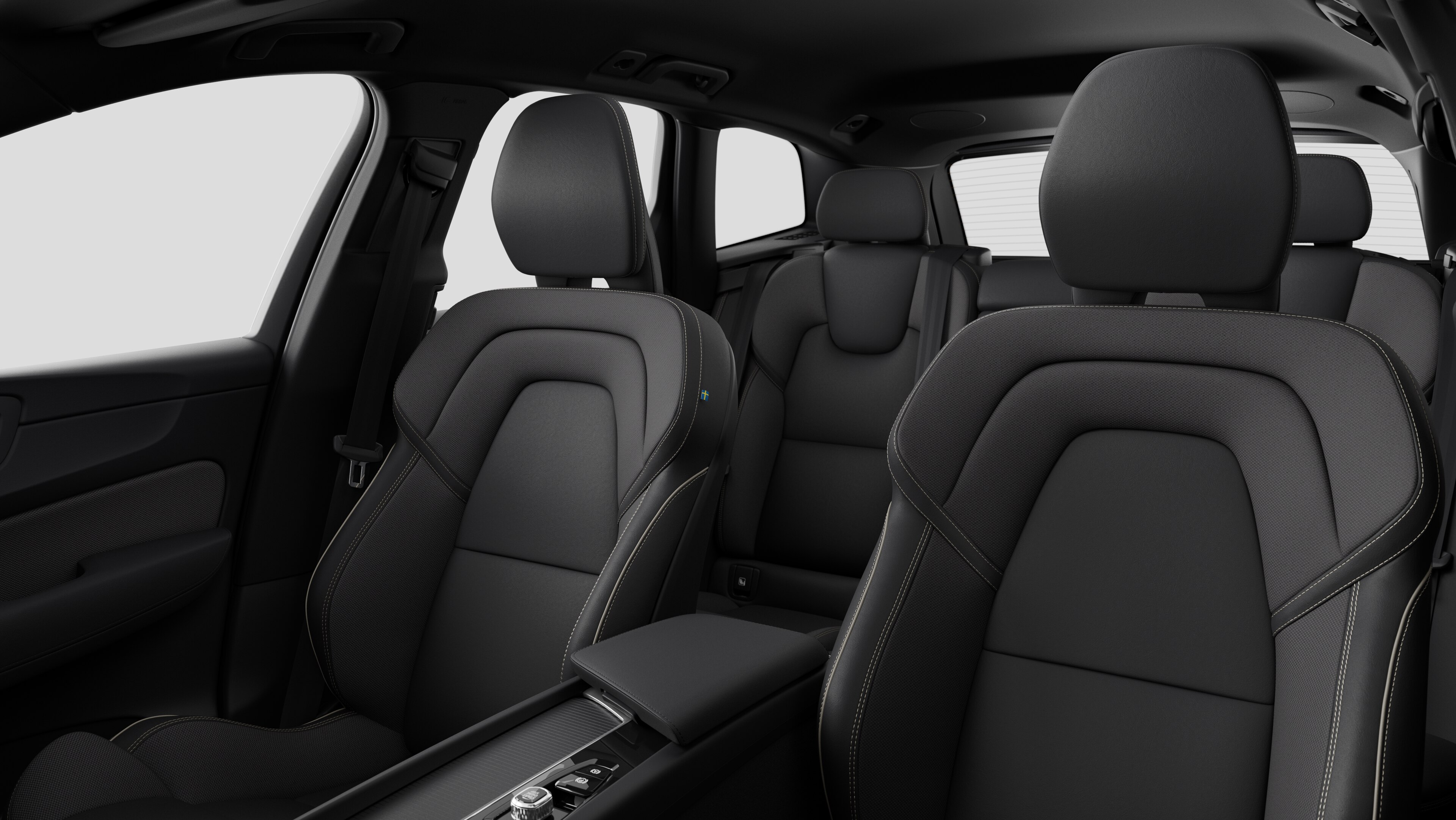 Wnętrze samochodu Volvo z tylnymi siedzeniami pasażerów i konsolą środkową na tle zwykłego studia.