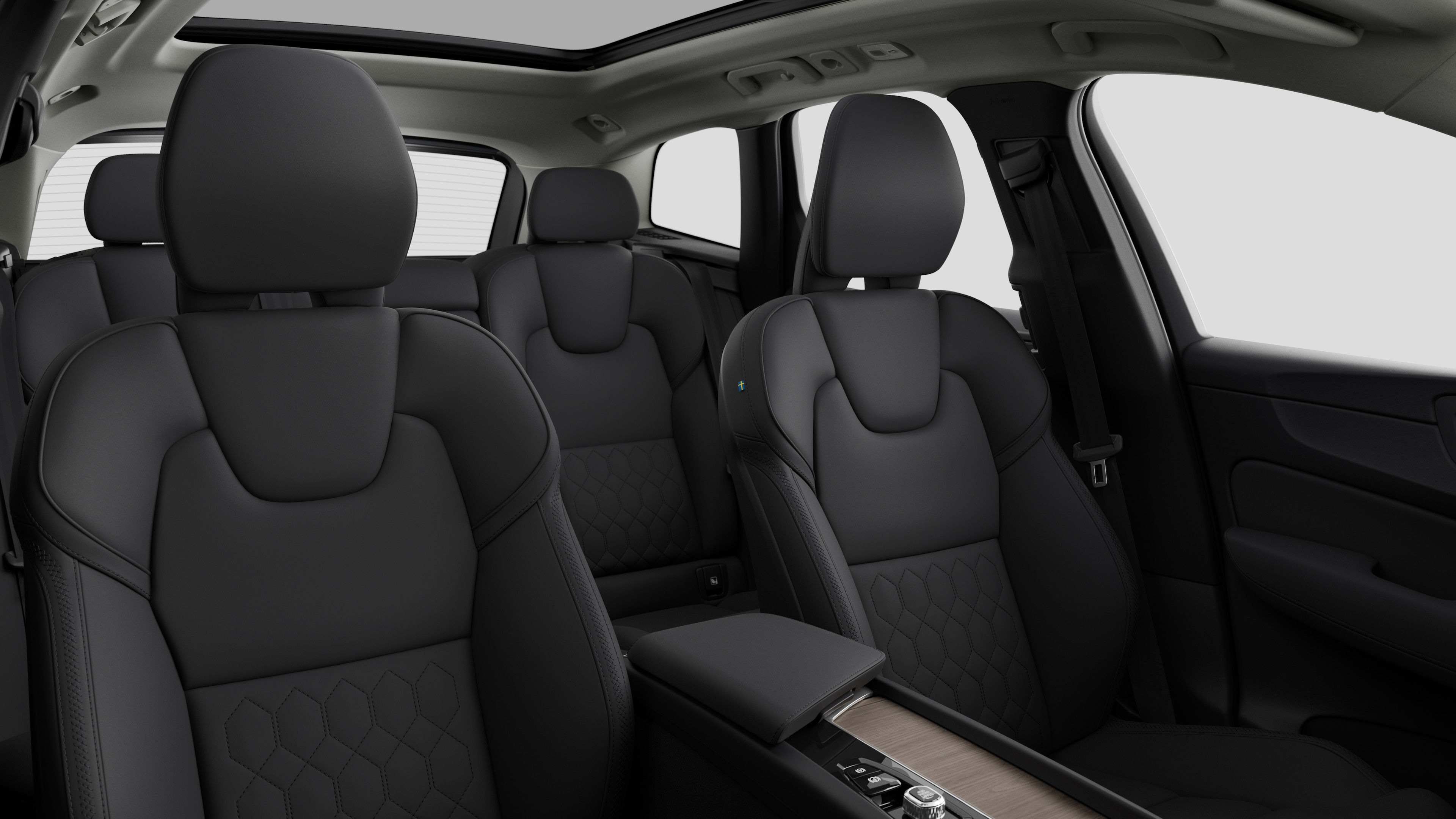Volvo car interior showing rear passenger seats and center console in plain studio background.