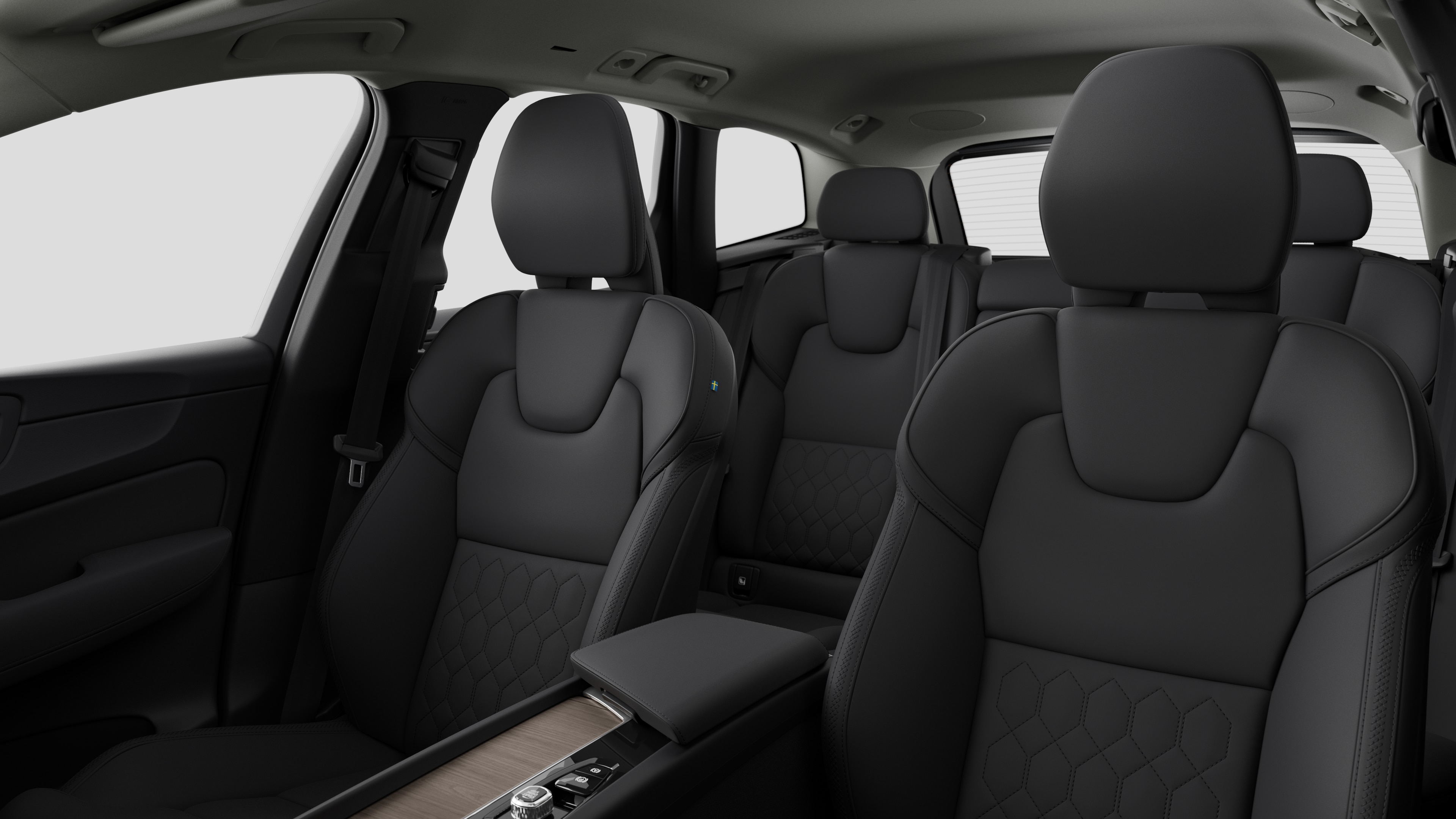 Volvo automašīnas salons ar aizmugurējo pasažieru sēdekļiem un centrālo konsoli vienkāršā studijas fonā.