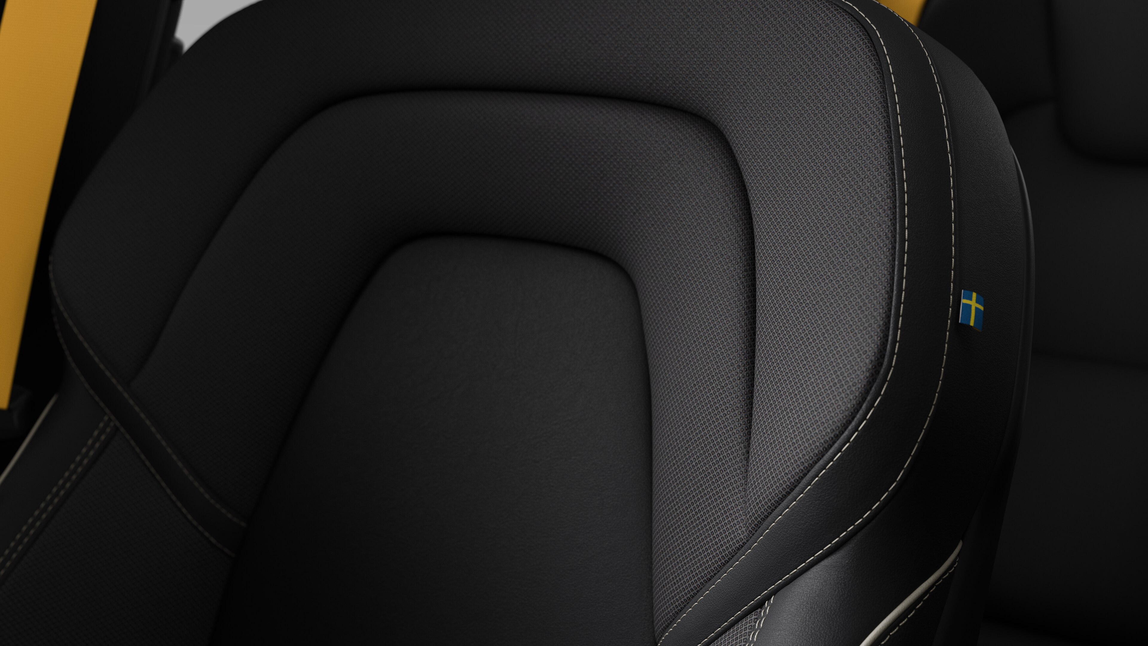 Close-up of Volvo car interior seat detail showing stitching and a small Swedish flag tag.