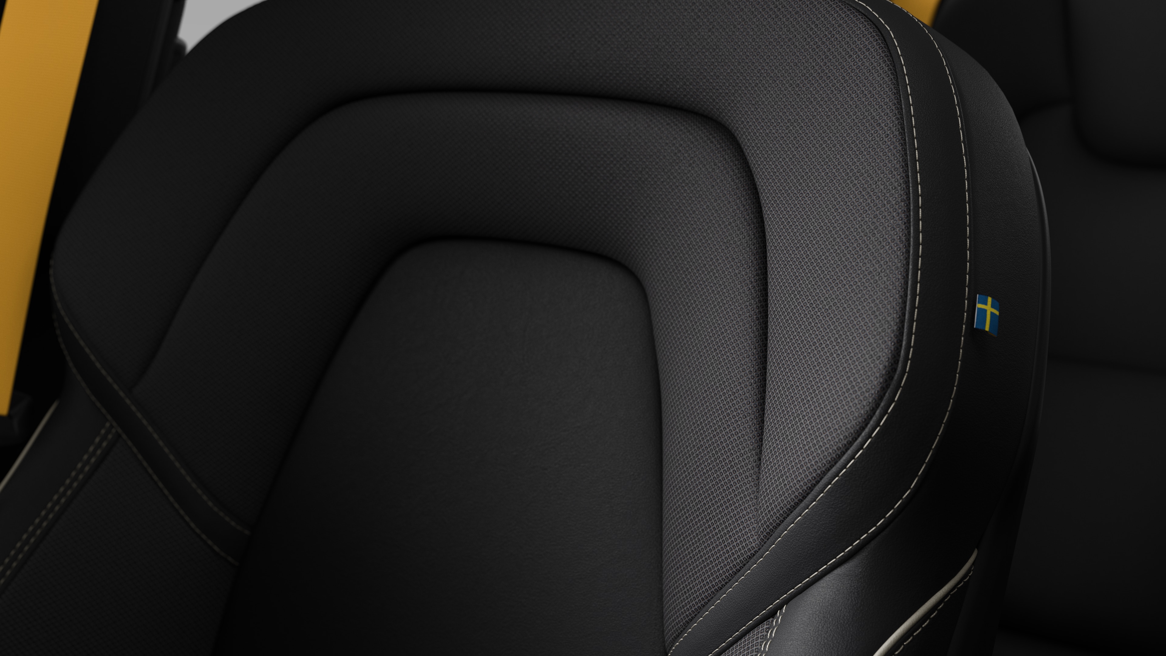 Close-up of Volvo car interior seat detail showing stitching and a small Swedish flag tag.