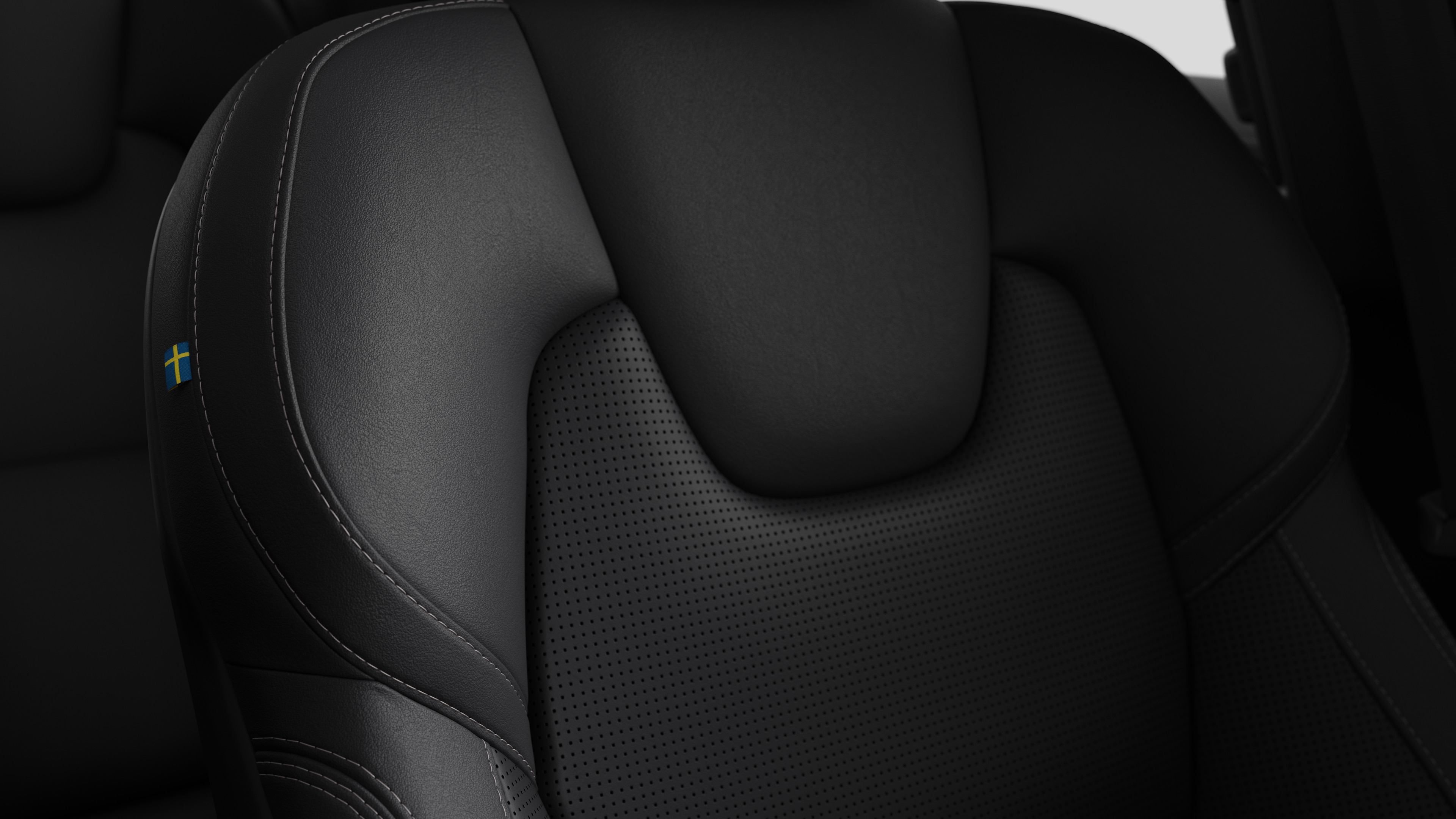 Close-up of Volvo car interior seat detail showing stitching and a small Swedish flag tag.