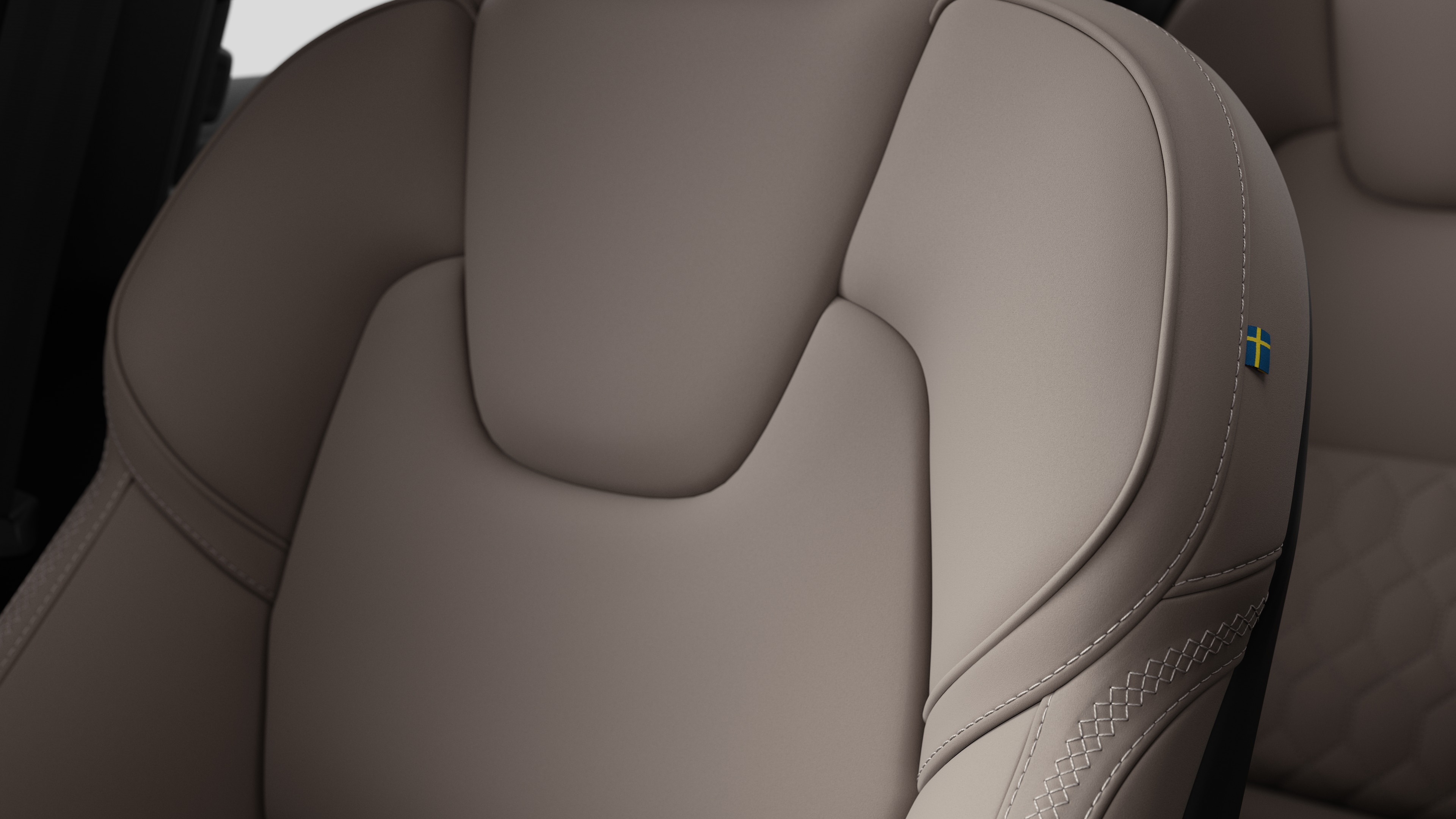 스티칭과 작은 스웨덴 국기 태그를 보여주는 볼보 자동차 내부 시트 디테일 클로즈업.