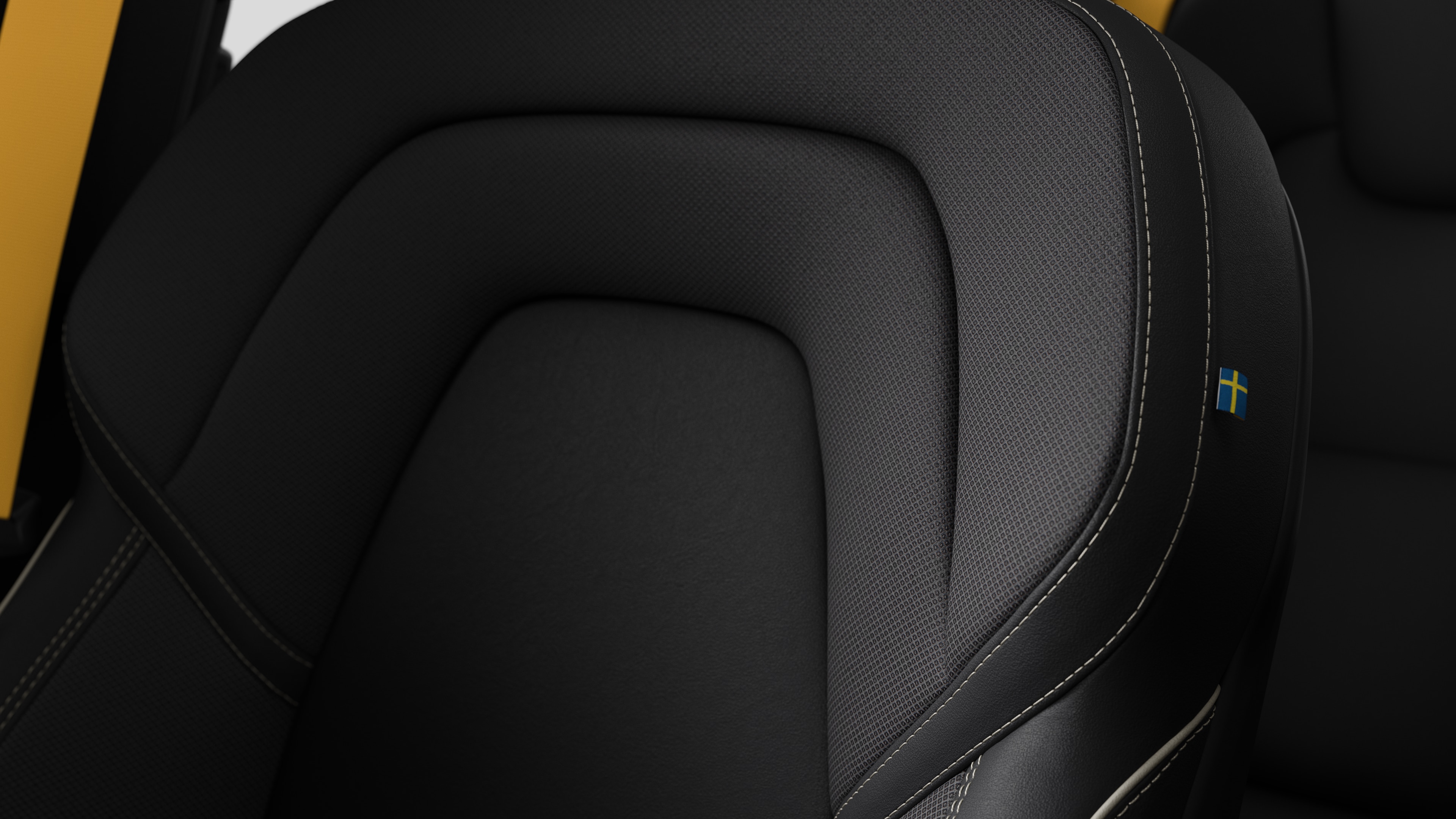 Close-up of Volvo car interior seat detail showing stitching and a small Swedish flag tag.