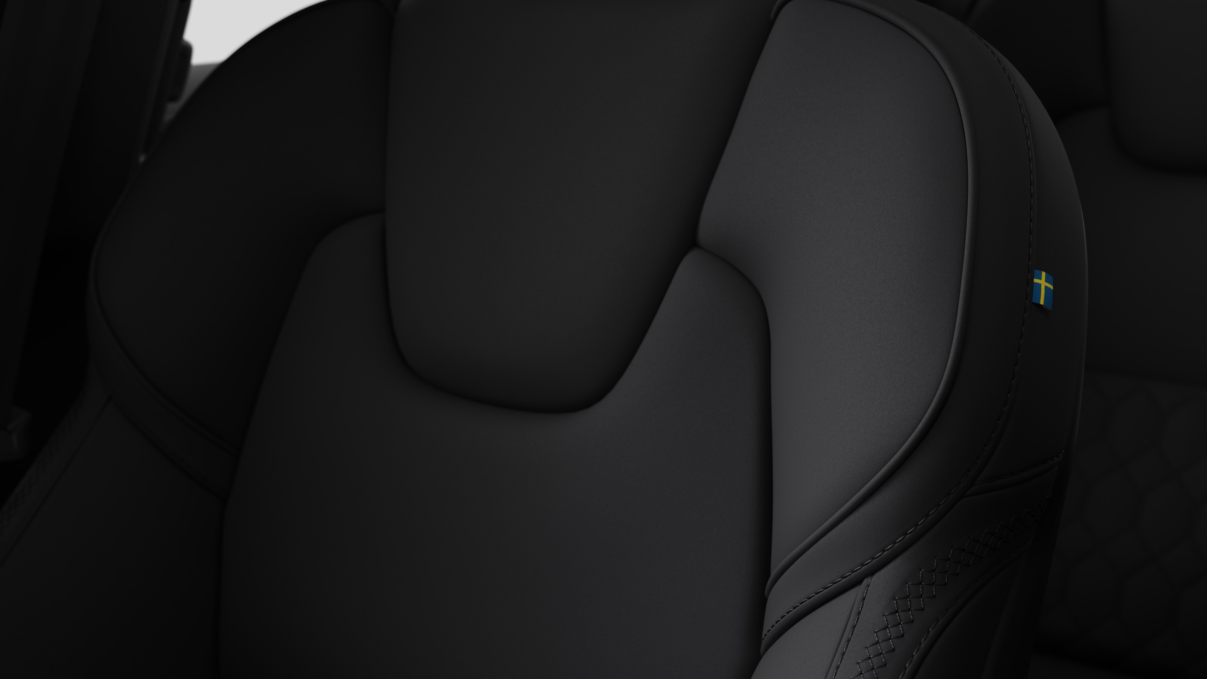 Dikişleri ve küçük bir İsveç bayrağı etiketini gösteren Volvo otomobilin iç koltuk detayının yakından görünümü.