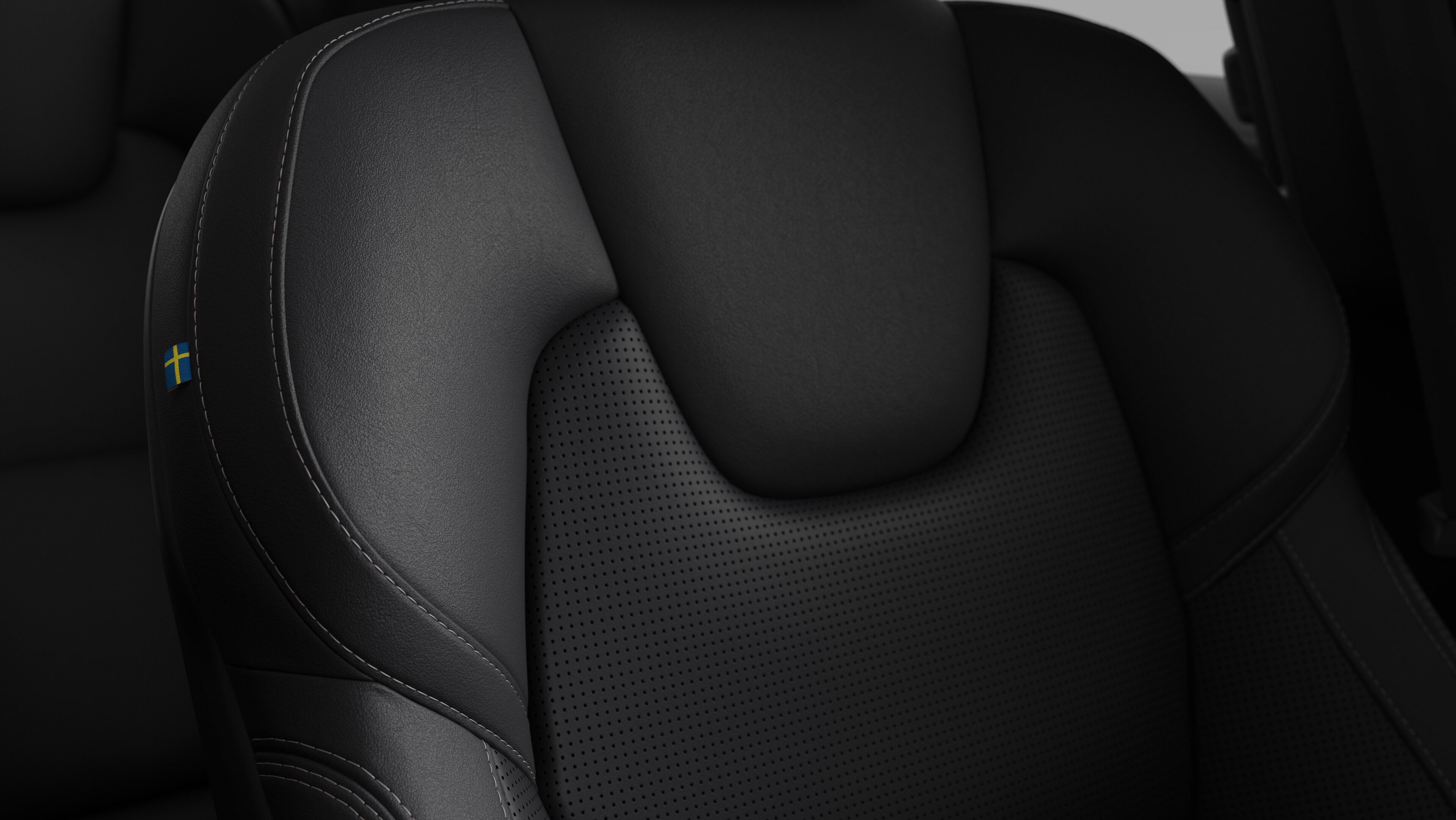 Close-up of Volvo car interior seat detail showing stitching and a small Swedish flag tag.