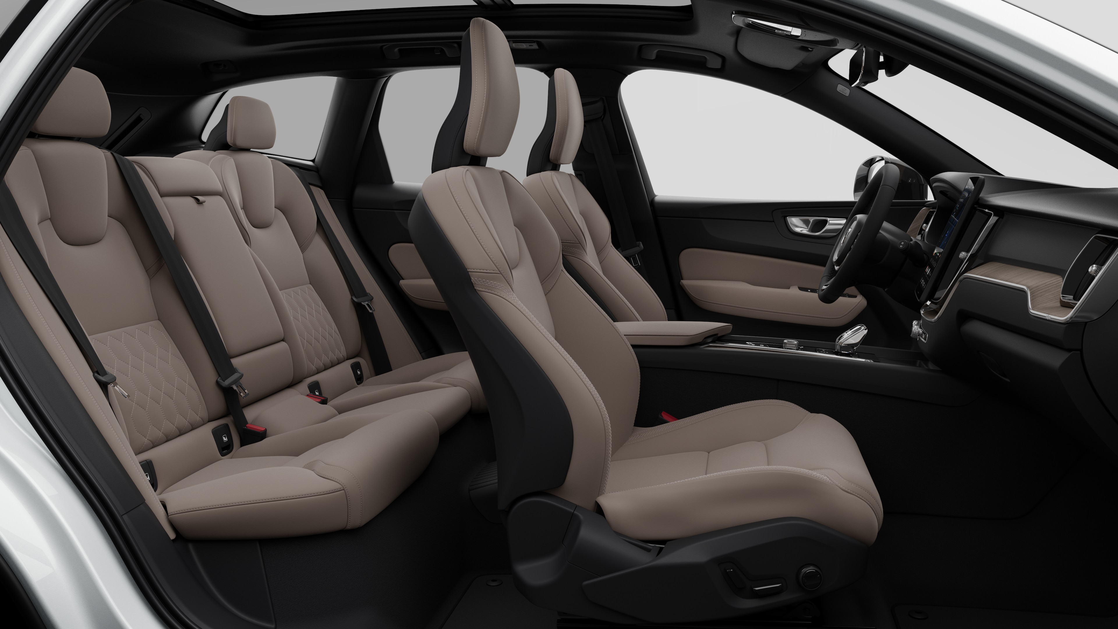 Vue latérale de l’intérieur d’une voiture Volvo mettant en valeur les sièges avant, les sièges passager arrière, le volant, le tableau de bord et la console centrale, sur fond de studio.