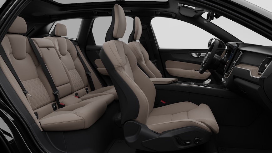 Vista lateral do interior do automóvel Volvo a mostrar os bancos dianteiros, os bancos do passageiro traseiro, o volante, o painel de instrumentos e a consola central, contra um fundo de estúdio simples.