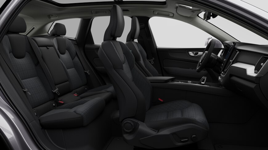 Vista lateral do interior do automóvel Volvo a mostrar os bancos dianteiros, os bancos do passageiro traseiro, o volante, o painel de instrumentos e a consola central, contra um fundo de estúdio simples.