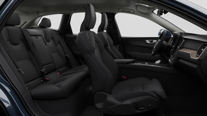 Vista lateral do interior do automóvel Volvo a mostrar os bancos dianteiros, os bancos do passageiro traseiro, o volante, o painel de instrumentos e a consola central, contra um fundo de estúdio simples.